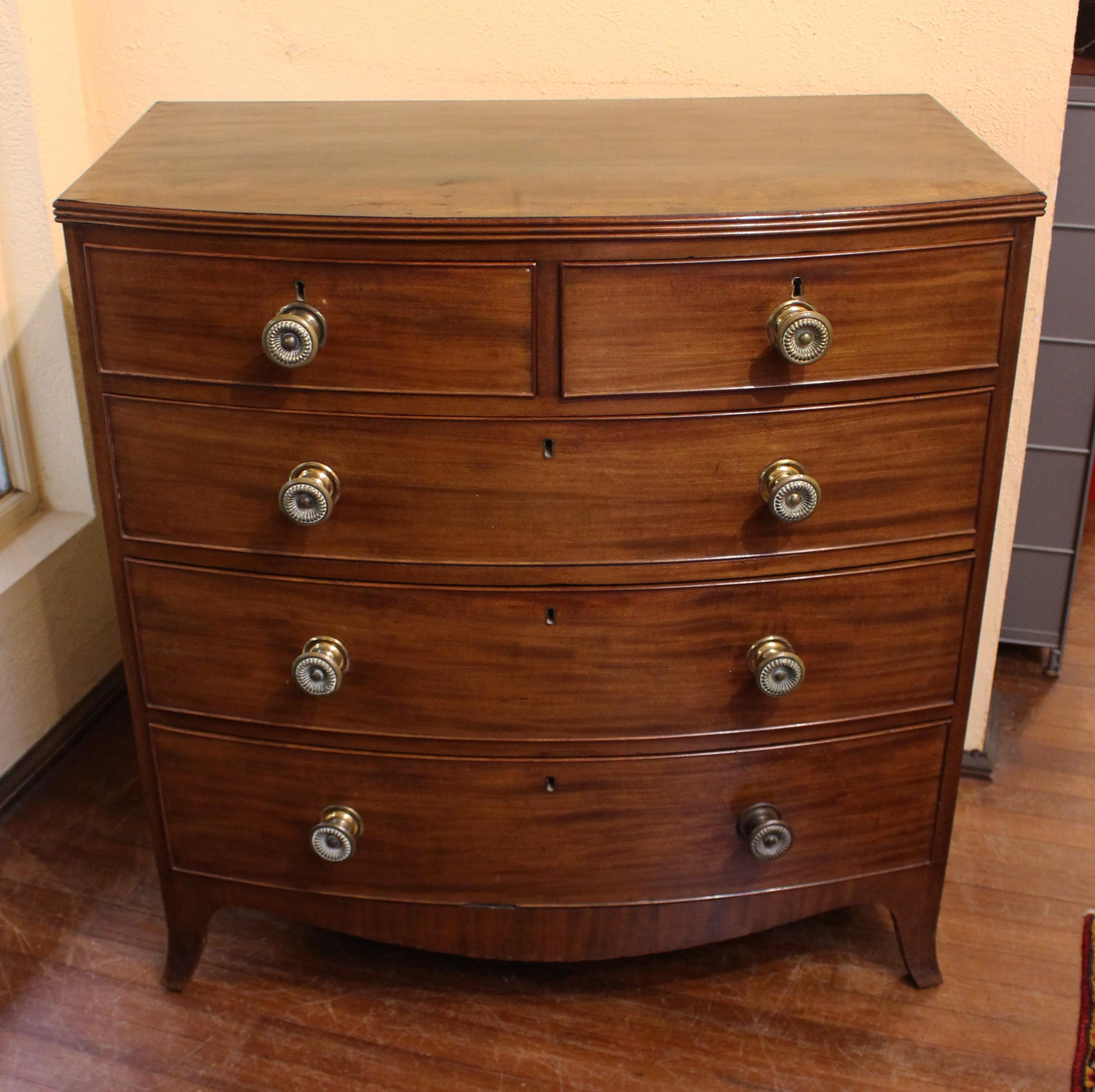 Regency period c.1800 bowfront chest of drawers, English. Two over three drawer form raised on French splay feet with shaped aprons. Triple reeded top. Well figured mahogany with oak & pine secondary woods. Original quality turned brass pulls with