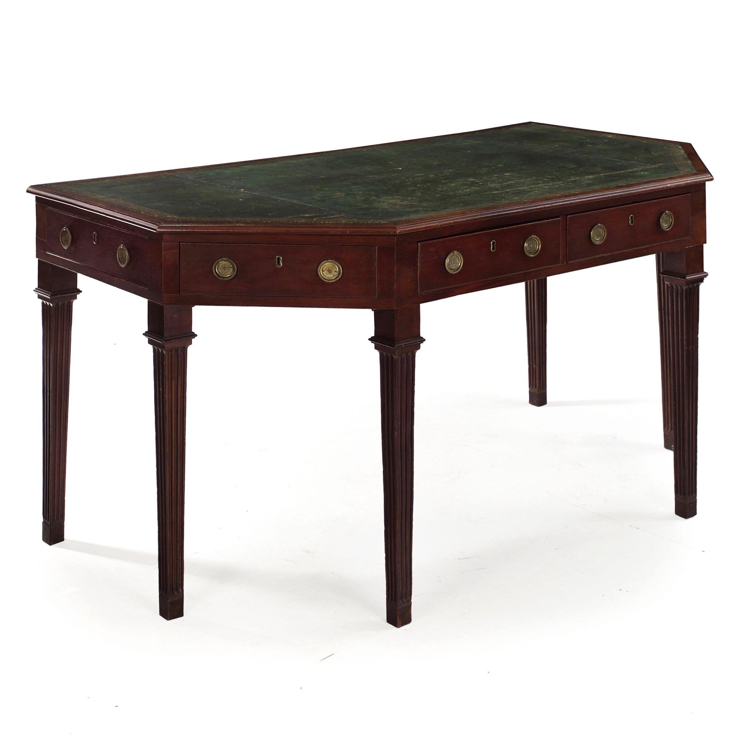 A superb writing desk preserved in excellent original condition, this fine George III period work features a faceted mahogany facade with a conforming leather writing surface situated over six drawers and raised on tapered-fluted legs.

The green