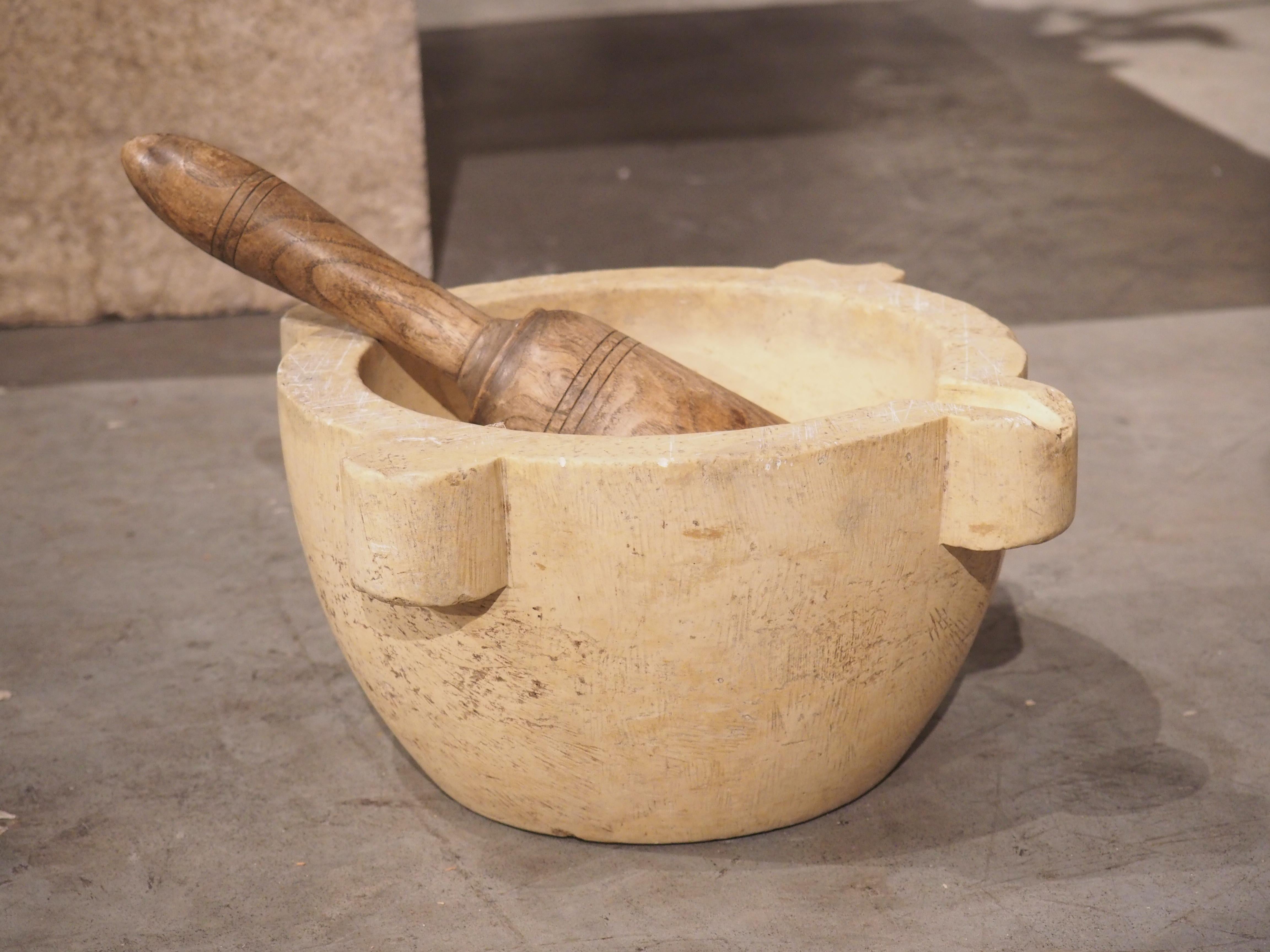 This very old carved marble mortar and wooden pestle dates to circa 1800 and originally came from France. The original use of a mortar and pestle was to aid pharmacists in crushing herbs into powder for medicinal purposes. In France, they were also