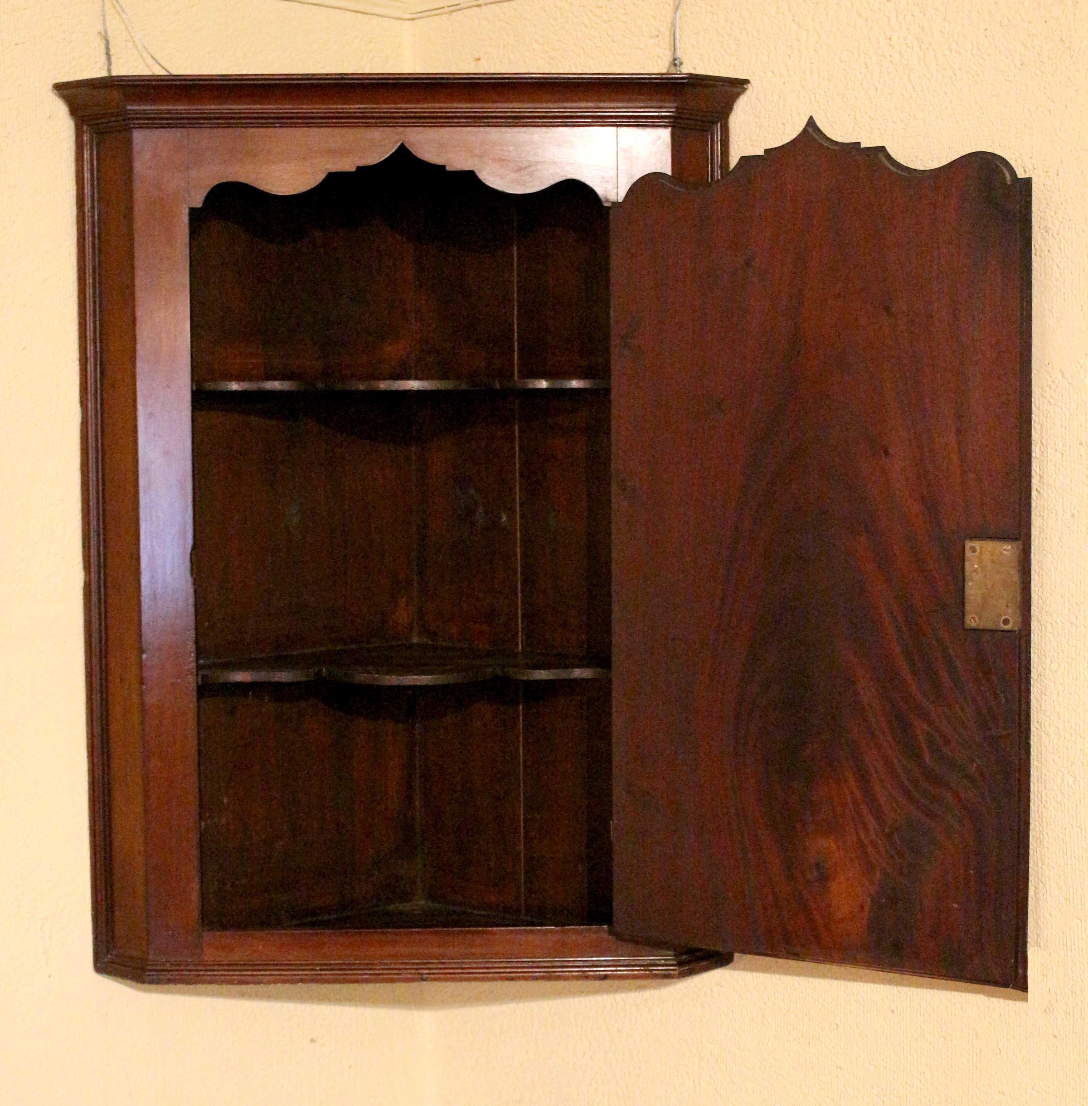 Cabinet d'angle à porte aveugle suspendue, circa 1800, anglais. Période George III. Les étagères intérieures en forme suivent la forme de la porte. Incrustation d'une étoile sous une incrustation ovale florale. Bien moulé autour de l'ensemble.
16