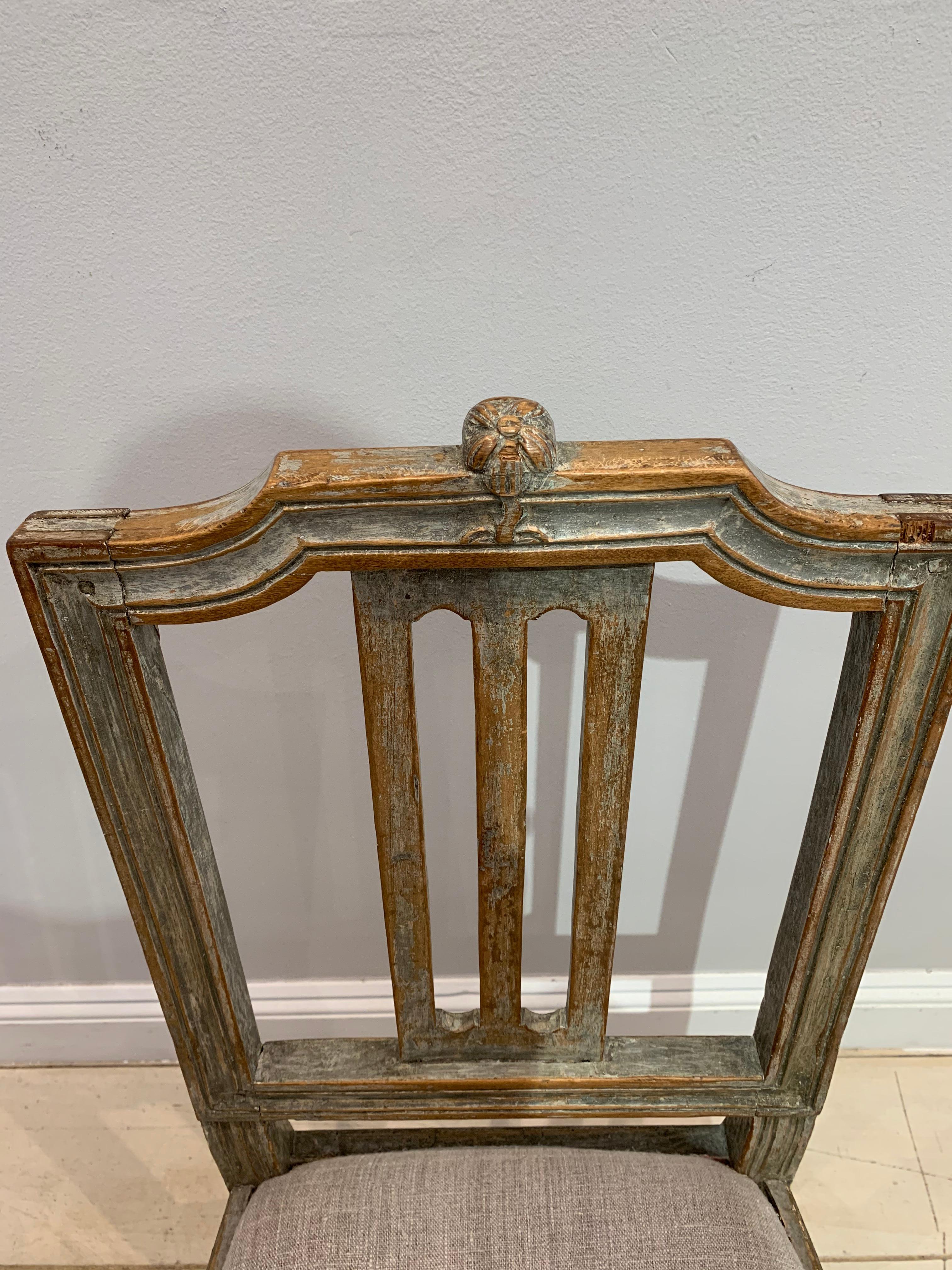 Delightful painted Swedish Gustavian chair from the late 18th century.
It has a decorative carved wood flower at the top, retains much of its original paint and has a drop in seat covered in neutral linen.
Likely from the Lindome region of Sweden,