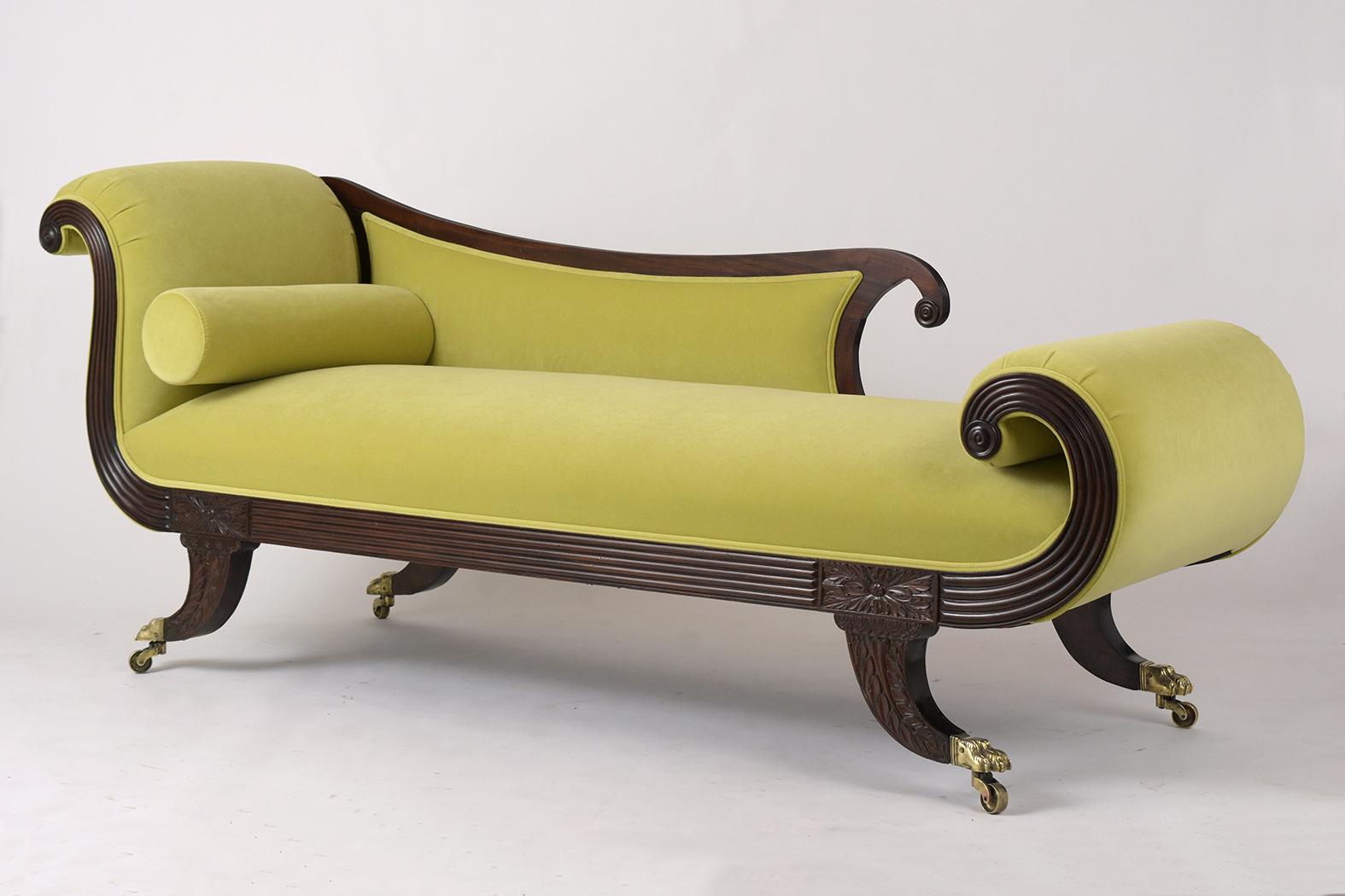 This English Empire style chaise lounge early 1800s is made out of solid Flemish mahogany wood and has been professionally restored. It features a scrolling design on the back armrest and legs and has remarkable hand carved details. The frame has