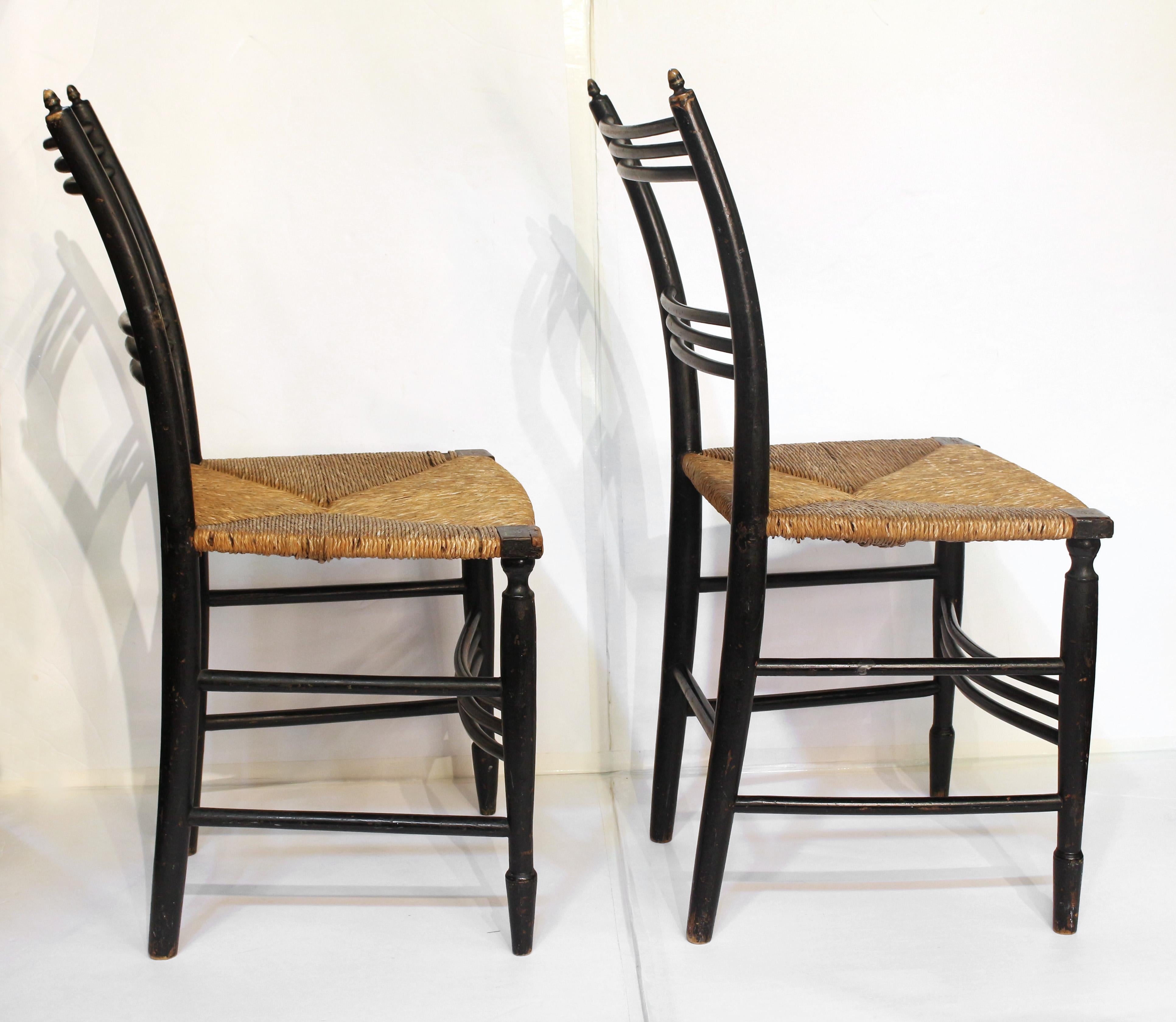 Pair of American rush seat side chairs, circa 1810-1820. Faux bamboo carved wood with black paint & gold highlights throughout. Acorn finials & concave triple front stretchers. Turned tapered front legs with end swell. One front corner lock worn &