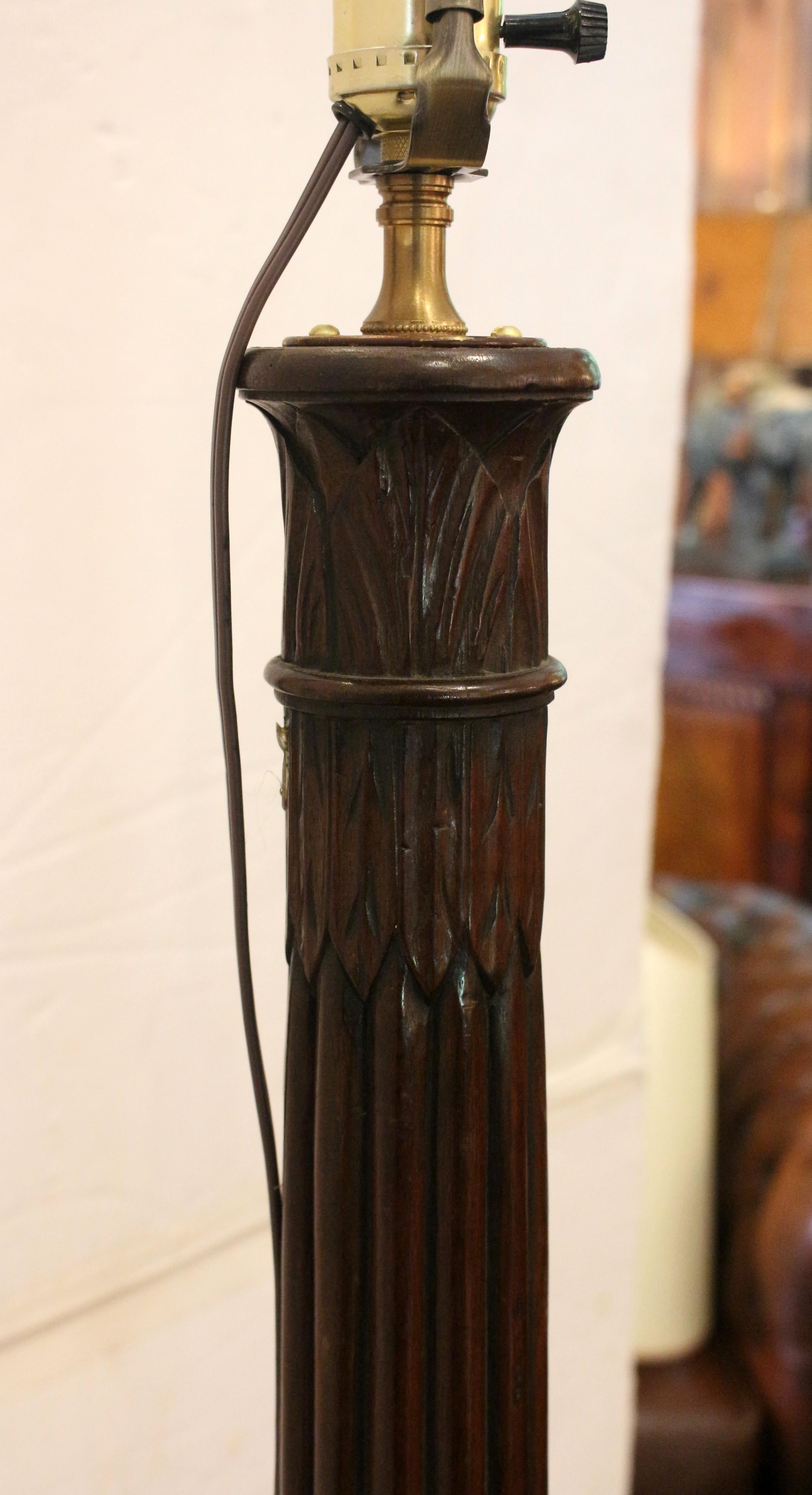 Circa 1810 Regency bedpost now as a floor lamp, English. Made into a torchiere in the Victorian era by adding shell carved ball & claw legs and now converted to a floor lamp. Mahogany. Water leaf carving descends to the boldly turned, reeded shaft