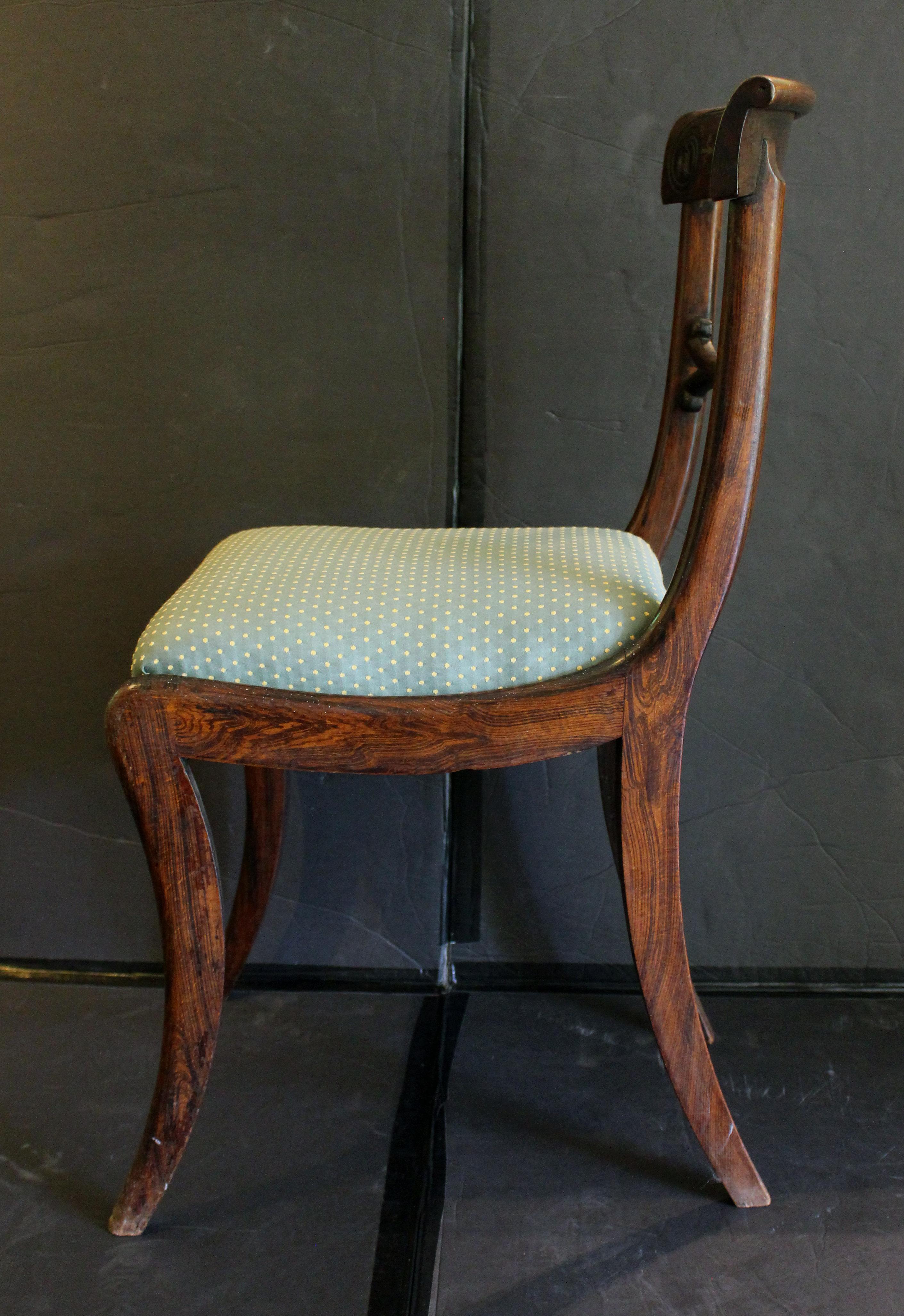 Sedia Regency inglese del 1810 circa, in ottone dipinto e intarsiato. Verniciato su faggio per simulare il palissandro. Sollevato su gambe a sciabola. Fiori di campana intagliati nella barra della cresta e utilizzati anche nell'intarsio in ottone