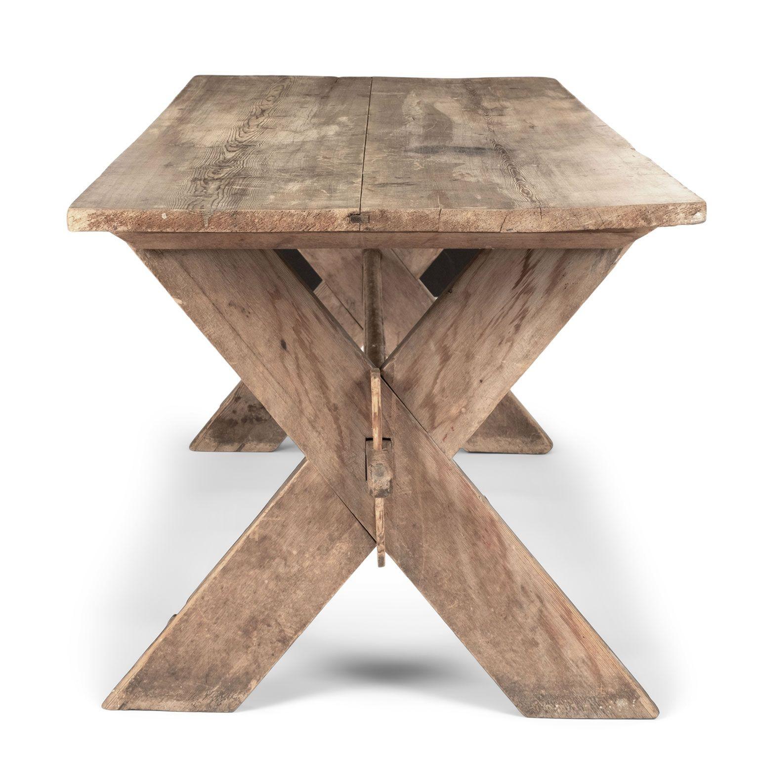 Circa 1810 Swedish pine rustic dining table hand-carved with beautiful patina and color. Supported by a trestle base and X-shaped legs.