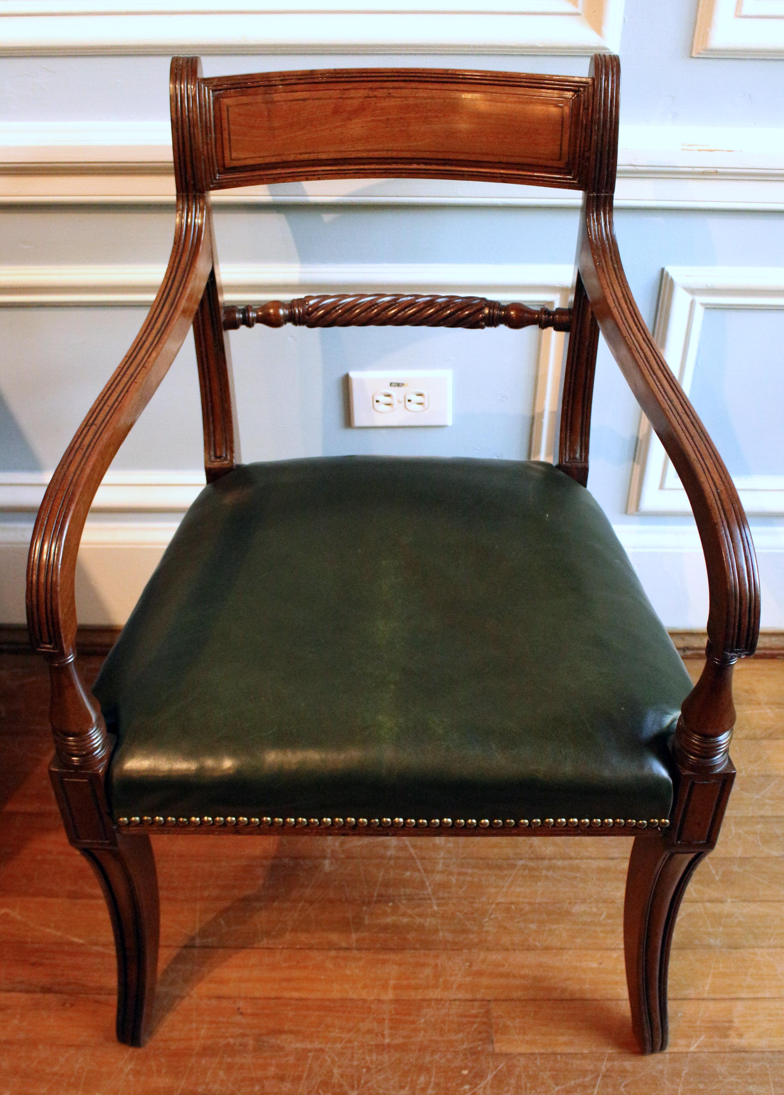 circa 1815 English Regency armchair with dark green upholstery. The reeded motif appears as a stylish contrast to the paneled motifs. Saber legs. 
34