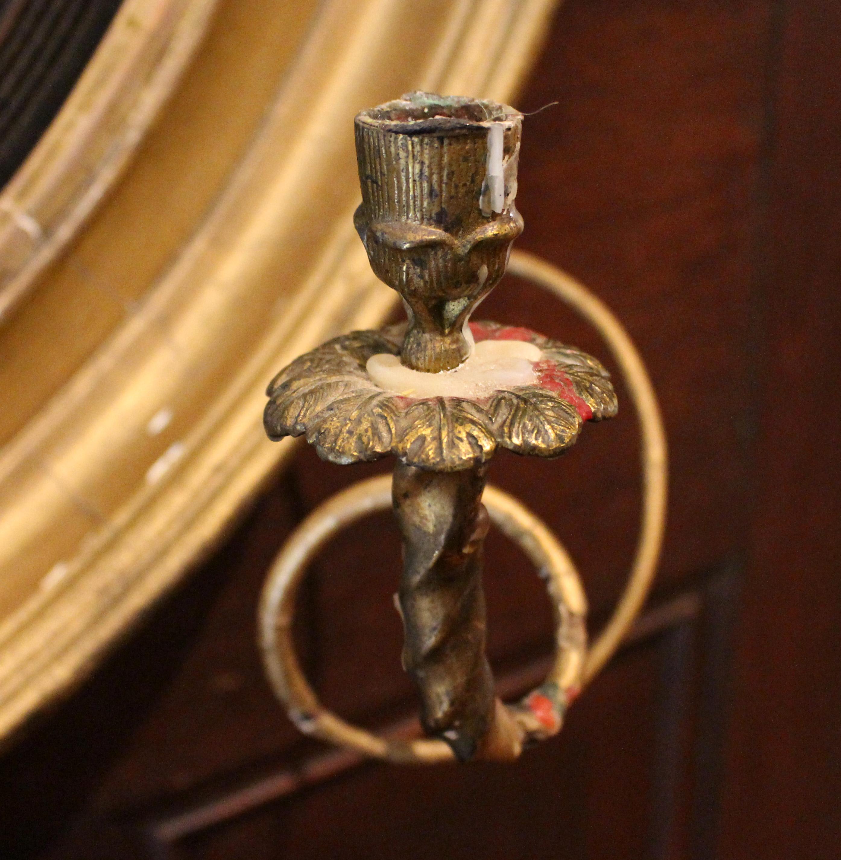 Circa 1815 Regency bull's eye girondole mirror, English. Carved wood, gessoed and ebonized & gilded. Original mirror plate with expected obscuring mercury deposits. Cast bronze & gilt, gessoed metal spiral girondole arms; lower central shell with