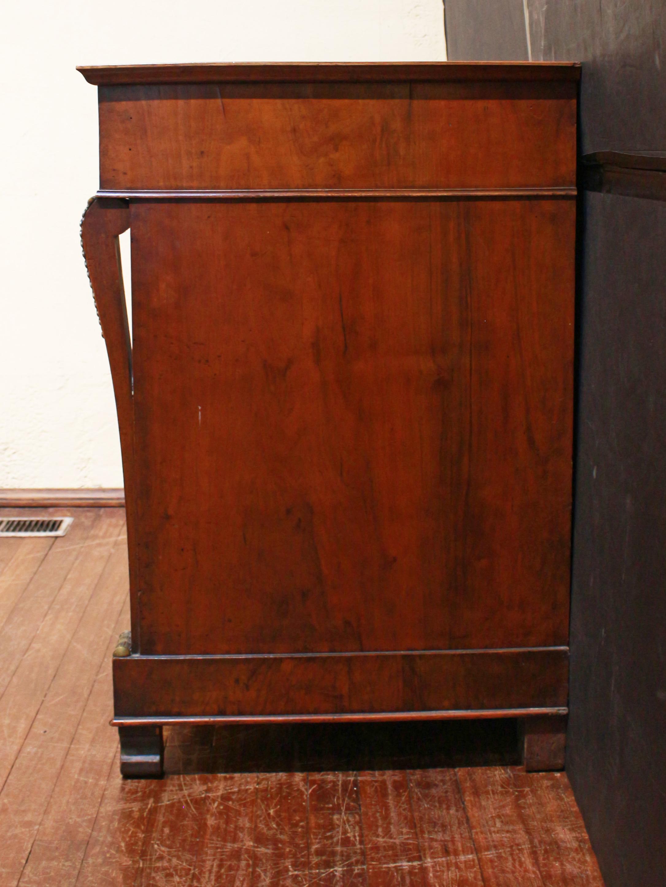 Commode Empire française à 4 tiroirs datant de 1815. Design/One sobre et élégant, typique de l'époque. Colonnes aplaties de forme subtile, avec des montures de bronze de qualité à l'endroit où elles s'élancent vers le haut ; pieds en forme, 3