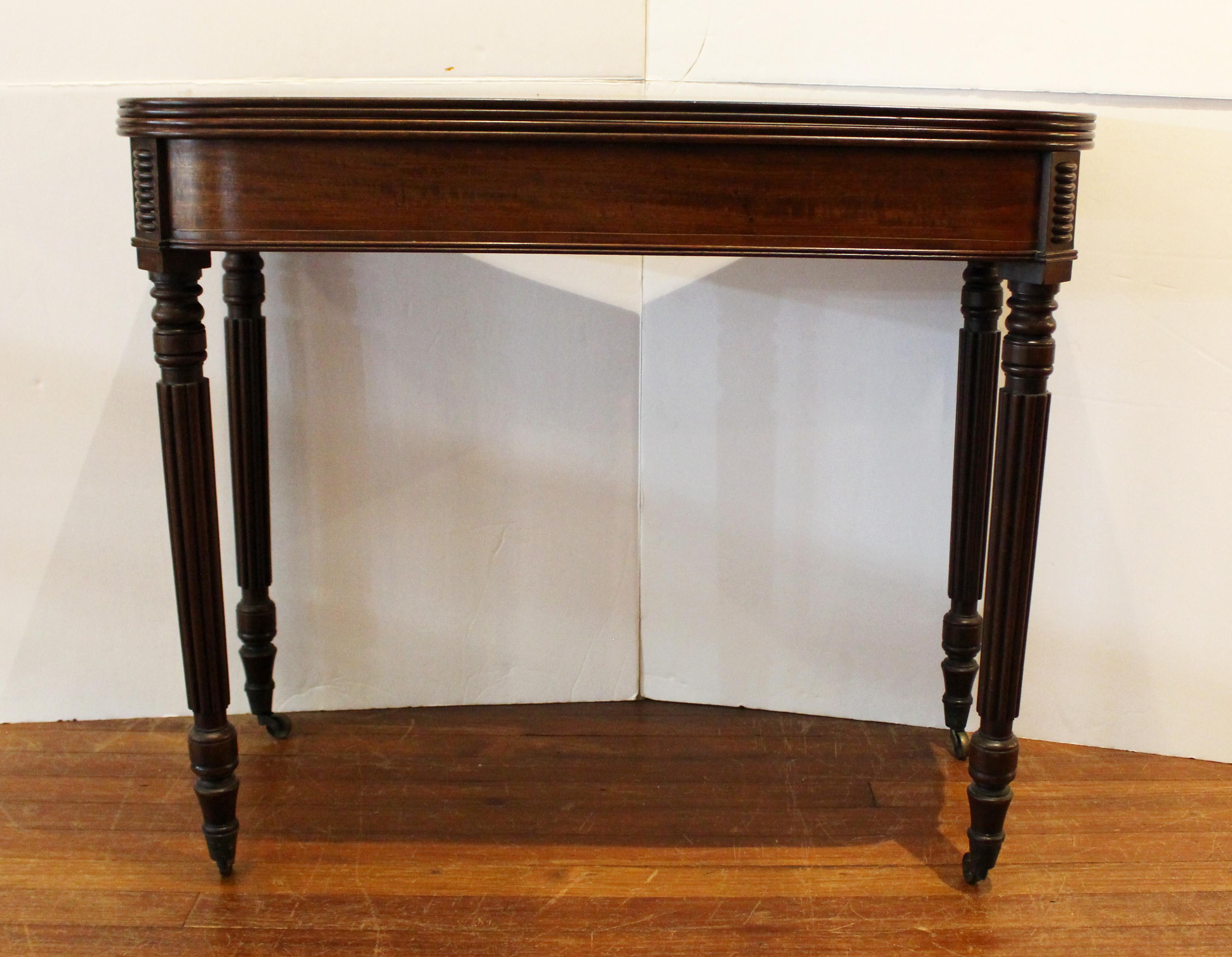 George IV to William IV c.1820-30 fold-top tea table, English. Console table form. Well figured, rich mahogany. Boldly reeded top, legs & corner friezes. Turned, tapered legs ending in brass caps & casters. Double gate legs swing out to support the