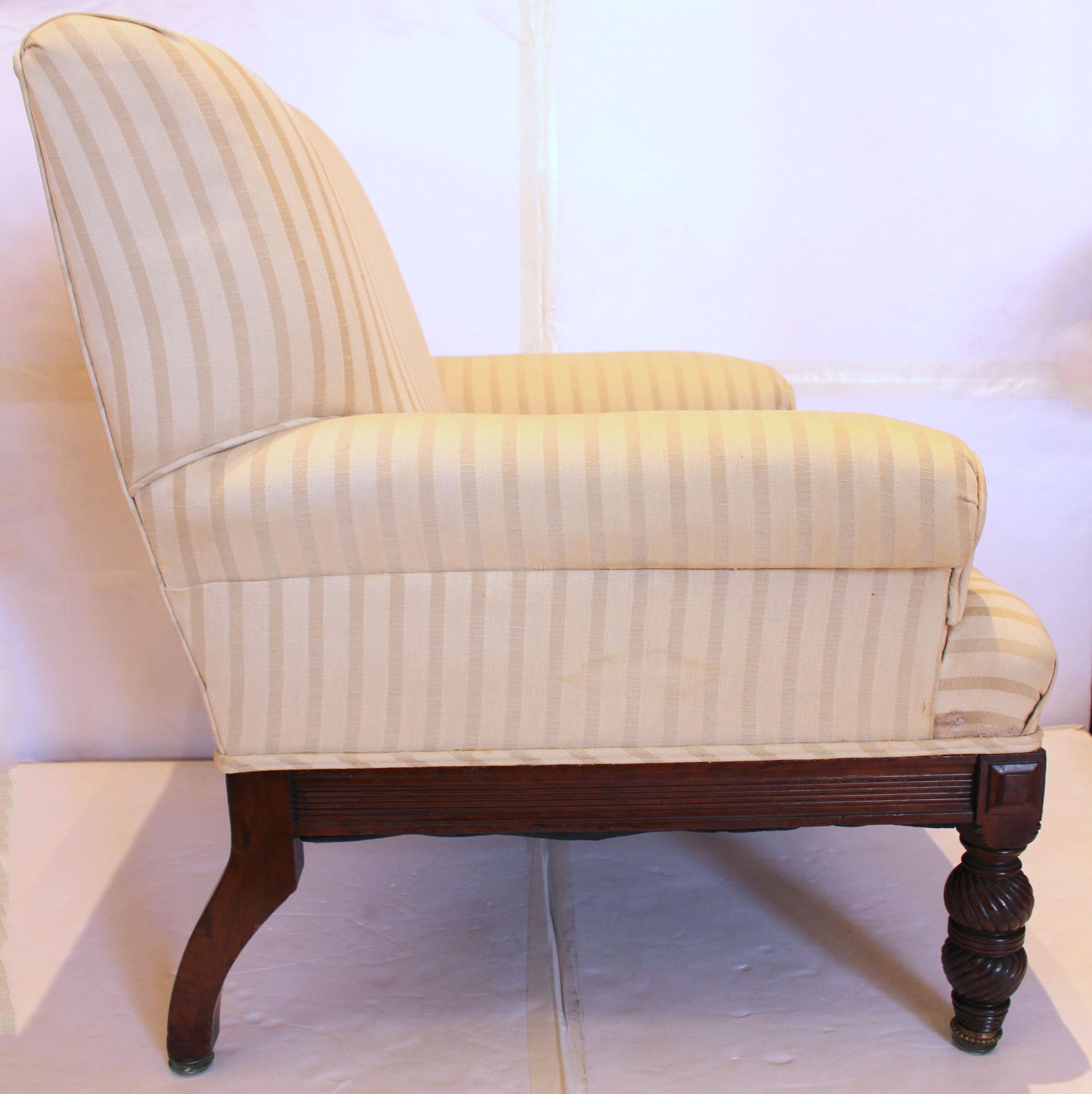 Circa 1820-30 George IV/Late Regency period library easy chair, English. Howard & Sons taste. Raised on swirl carved, turned front legs & arched rear legs. Reeded aprons. Brass caps. As found upholstery.
26.5