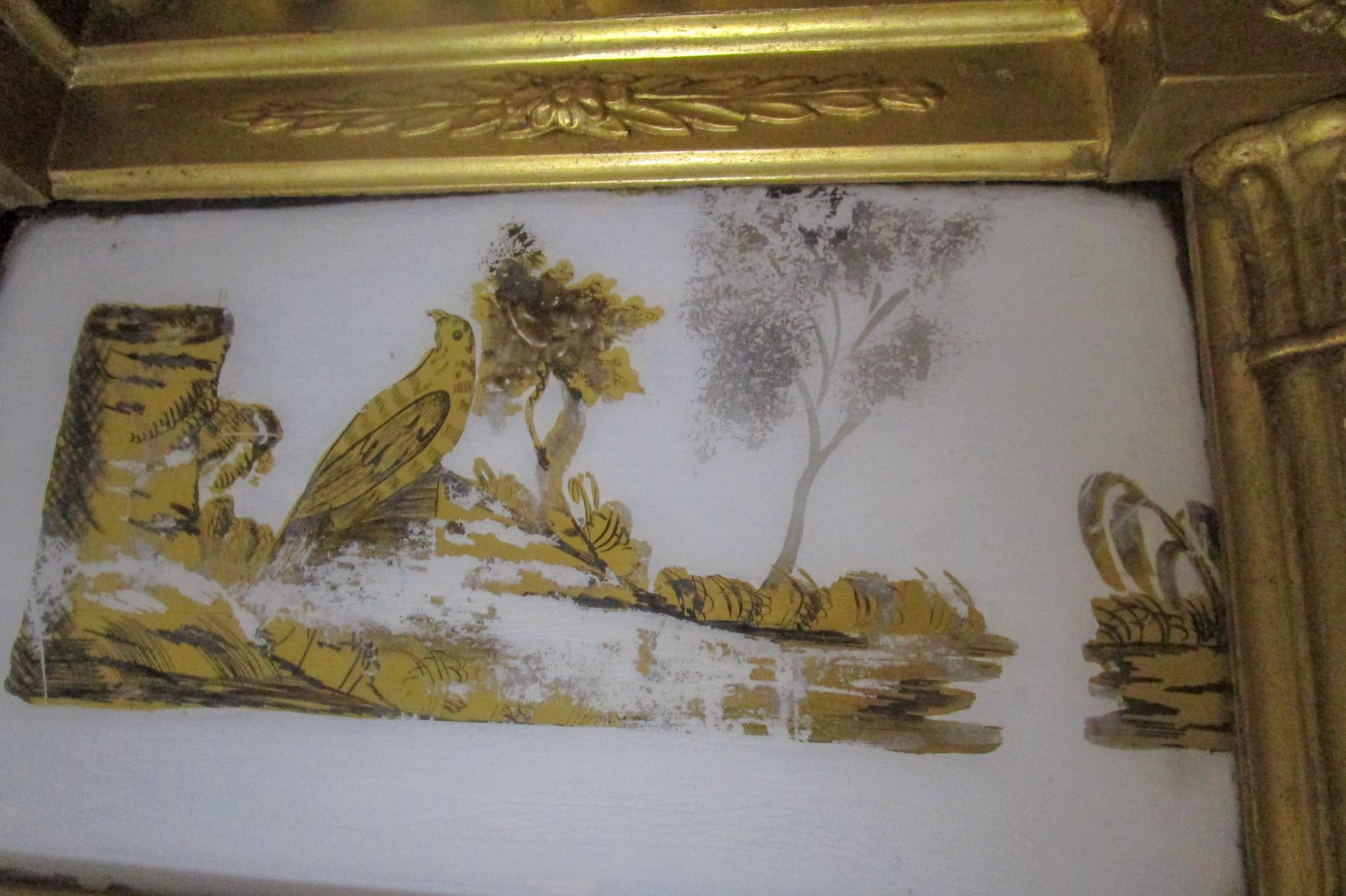 Vers 1820, ce miroir en bois doré de style architectural est orné d'une tablette en forme d'églantier peinte à l'envers et flanquée de colonnes cannelées, de perles et d'appliques. L'historien Rodric Blackburn écrit que 