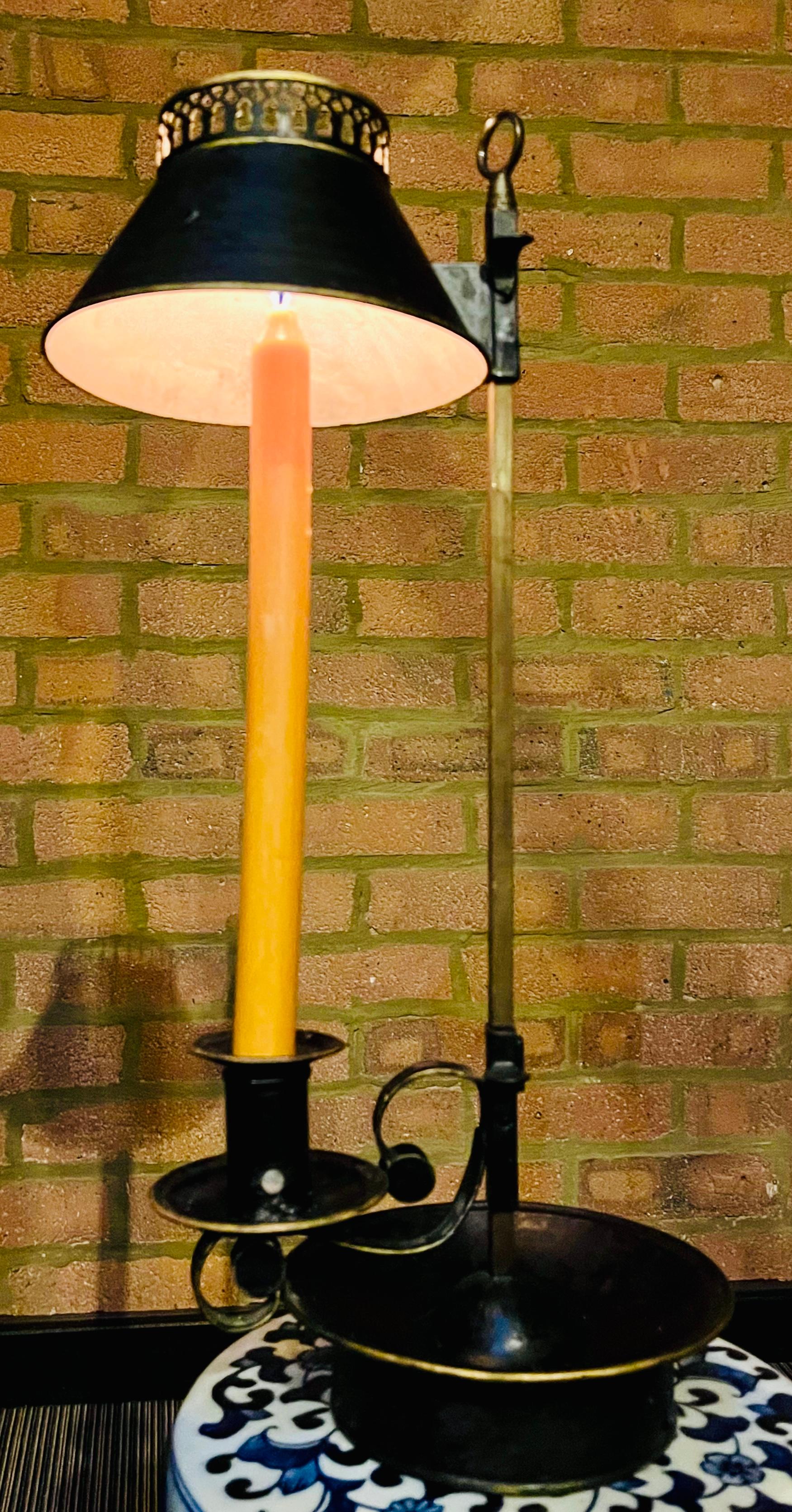 Magnifique lampe de table ancienne, vers 1820, d'époque Régence, en laiton et peinture noire/dorée Tole Bouillotte. La lampe est dotée d'un abat-jour réglable en forme de tole.  a été peinte à la main en noir avec des bordures dorées et finie avec