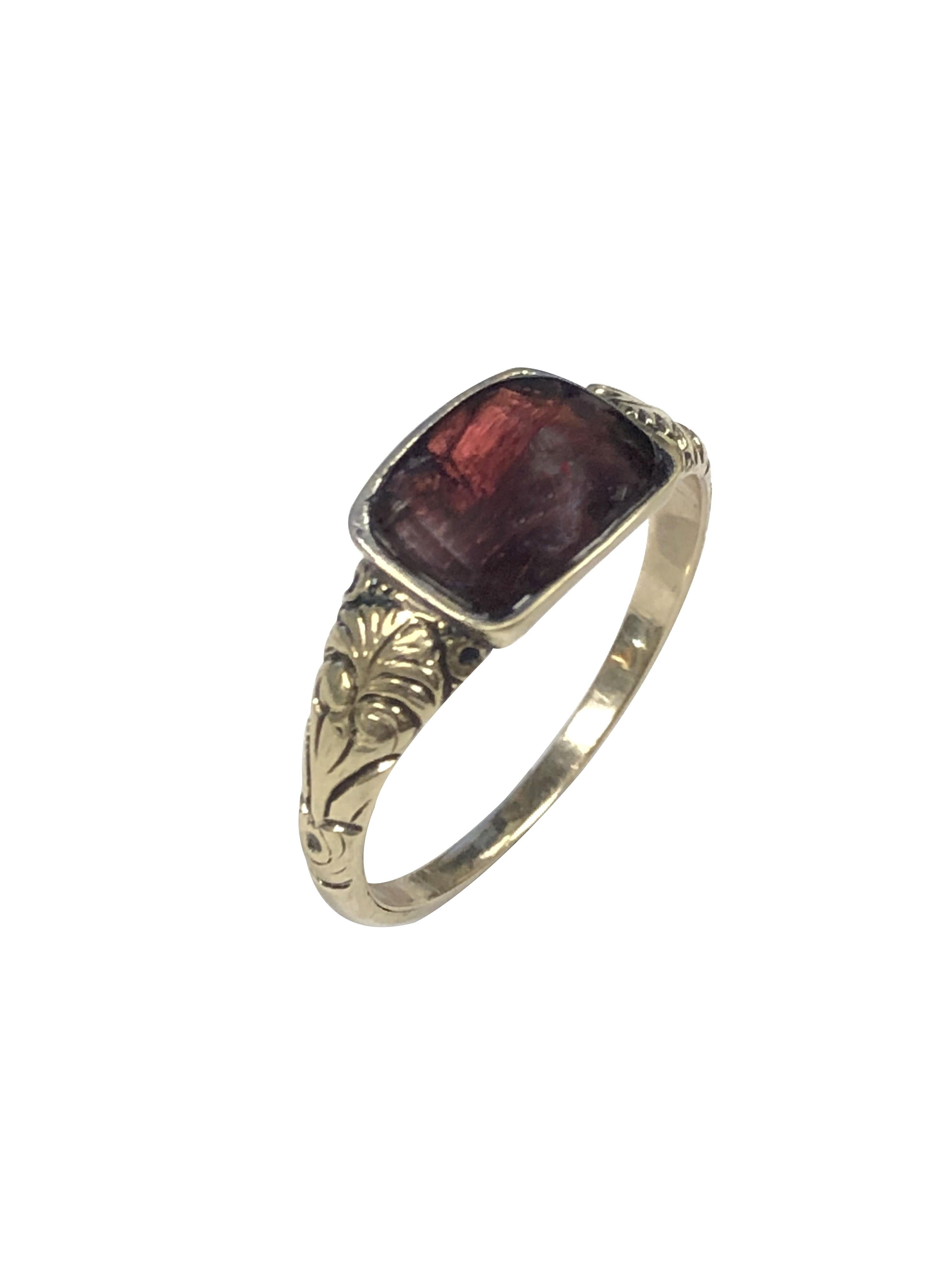 A Georgian Era ring in 14k Yellow Gold, set with a Cabochon Garnet, the top of the ring measures 1/2 x 5/16 inch. chased design work on the sides, finger size 6 1/2, incredible condition for a piece of this age, most likely a keepsake that was
