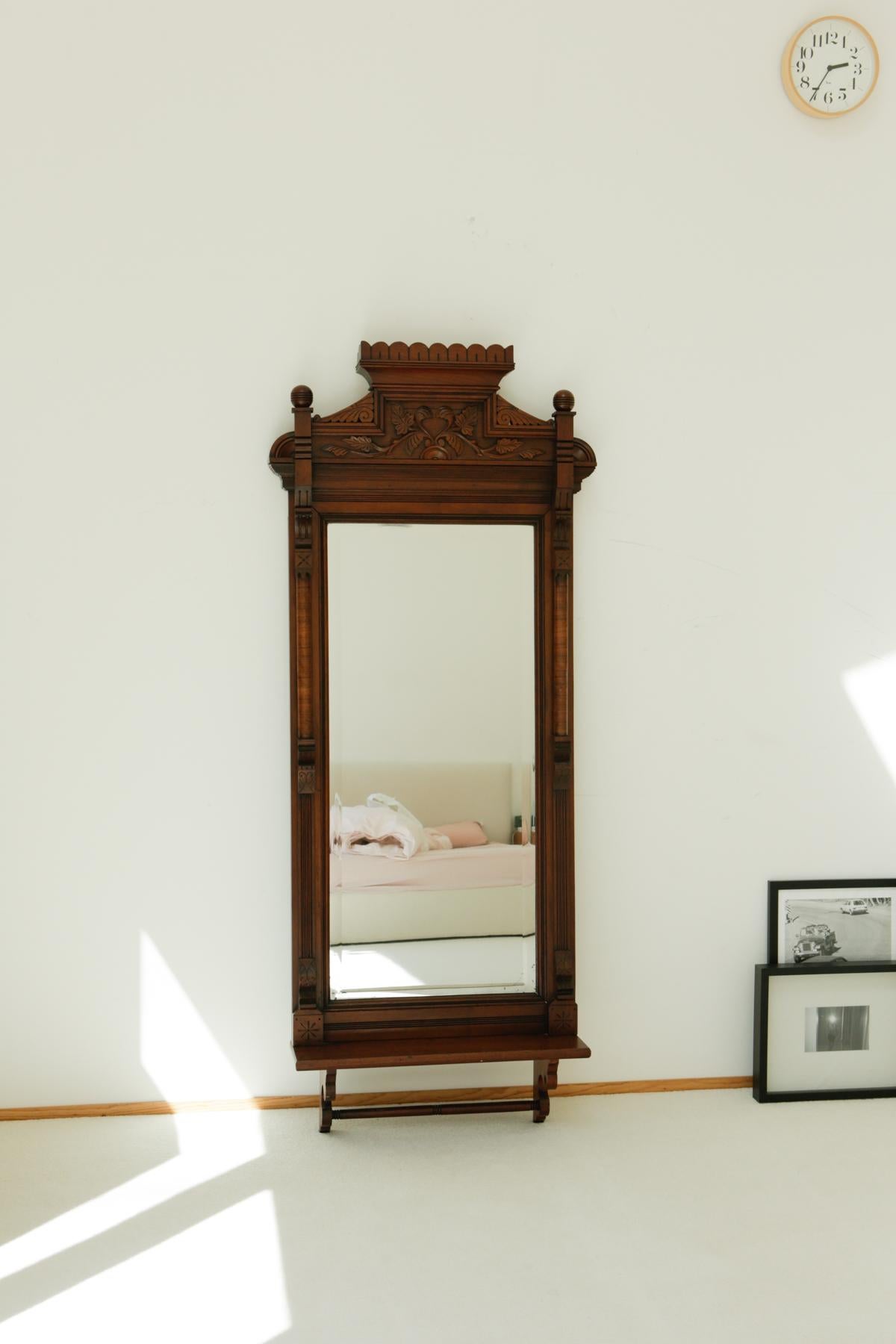 Circa 1820s carved solid mahogany wall mirror with shelf.

Say hello to your next best mirror! At the top of the finely carved wood arch are leaf engravings, forming a heart shape in the middle. Comes with a small shelf or vanity space. Great for