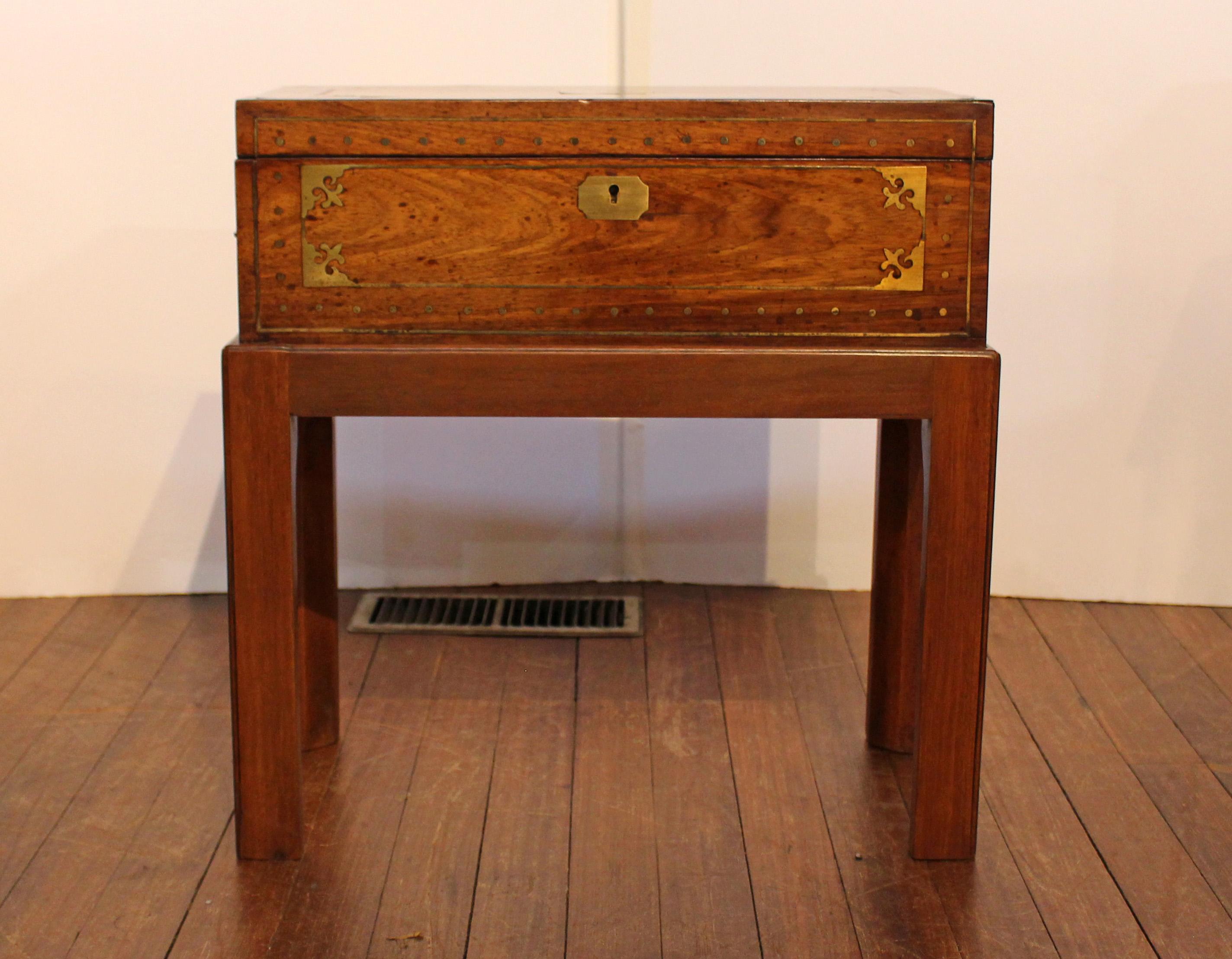 Circa 1820s English lap desk box now on custom made stand for a side table. Late Regency to George IV period. Rosewood with brass line, dot & fleur de lys motifs corner inlays, as well as monogram panel (unused), escutcheon and flat handles recessed
