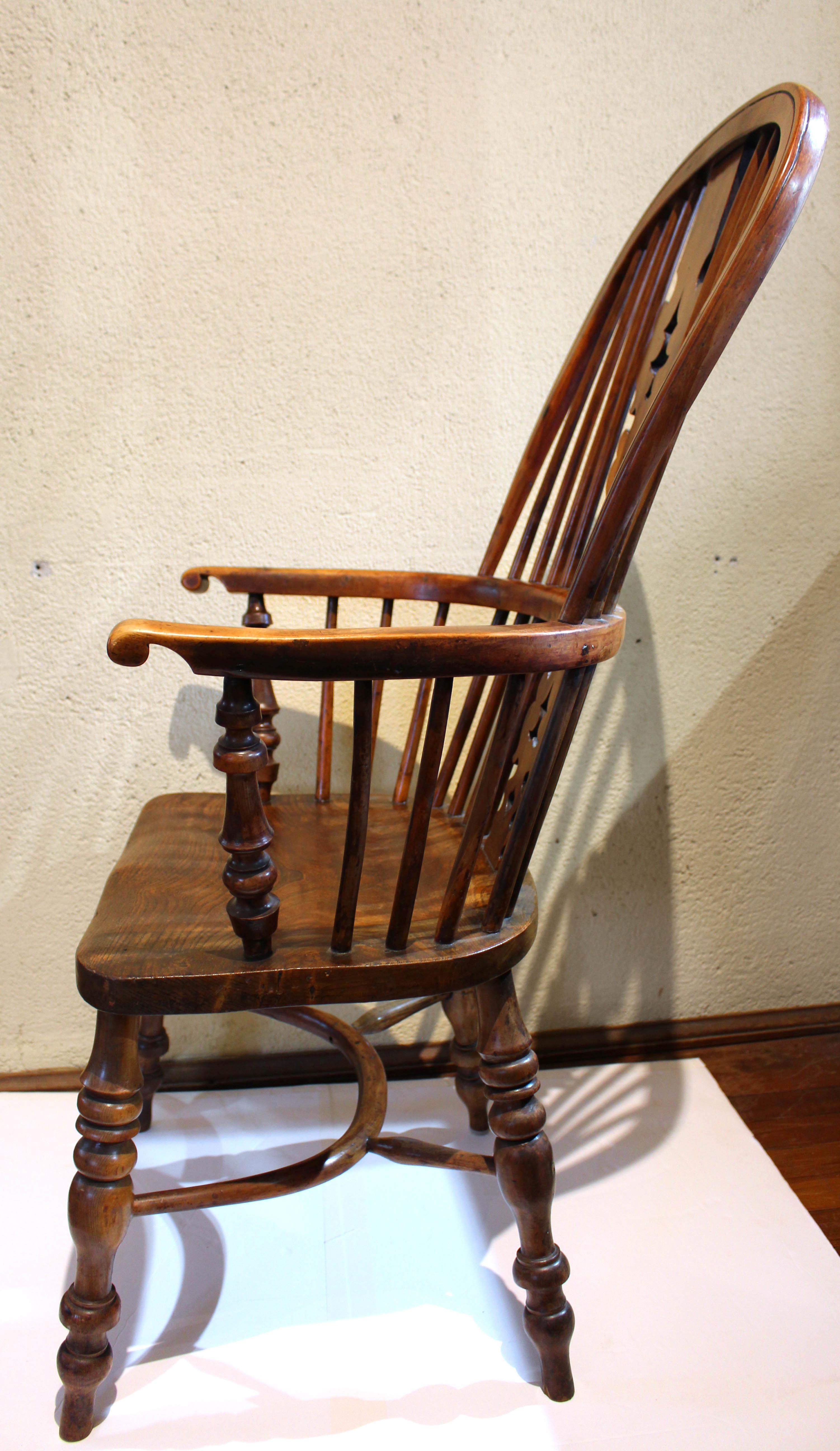 Circa 1830 English high back Windsor arm chair, yew wood. This sturdy, comfortable chair has desired 