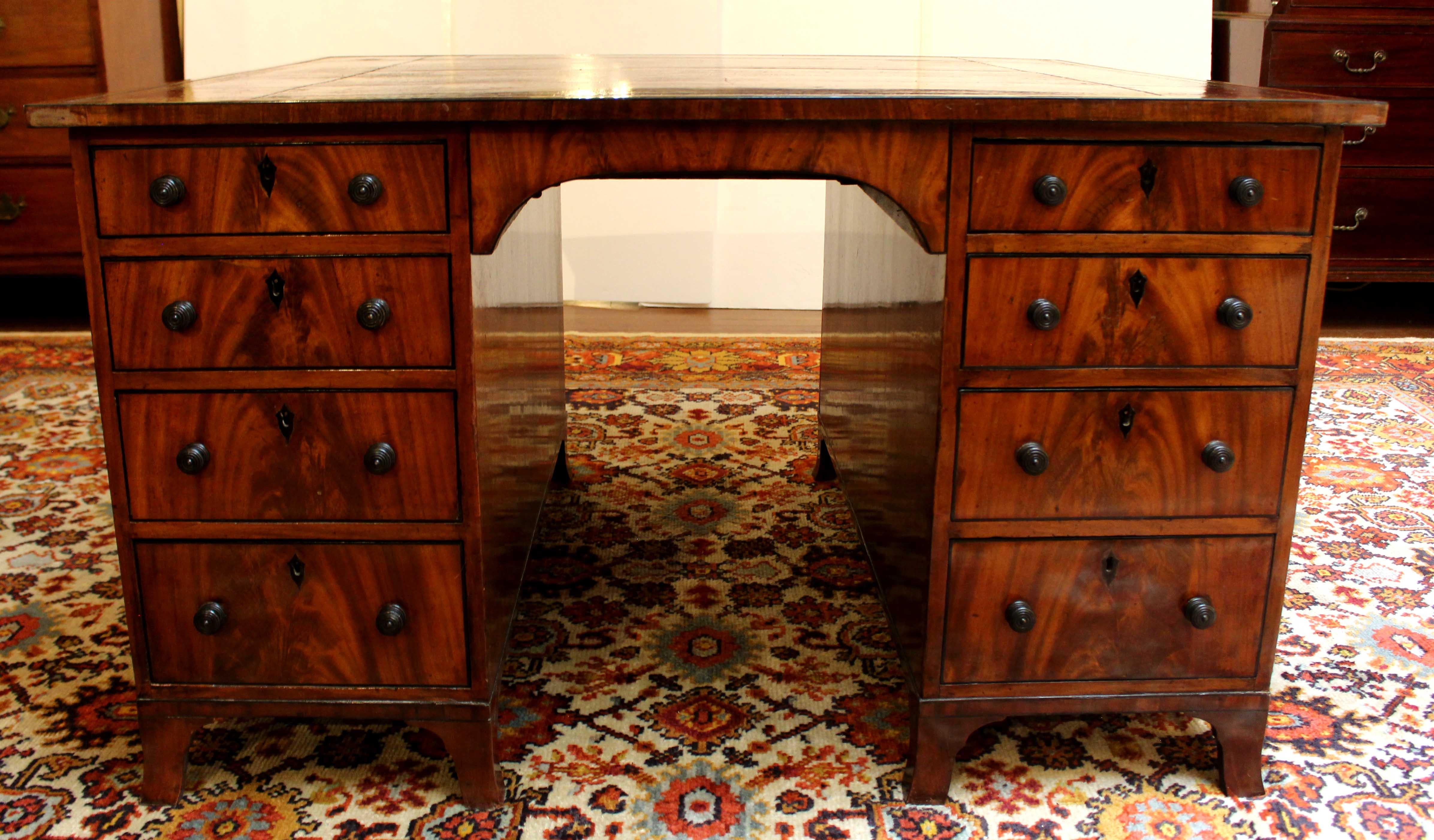 Circa 1830 partner's desk, English. Late George IV period. Mahogany with oak secondary wood. Nice selection of mahogany with the flame running all the up the drawers on one side and the cabinet doors on the other. Nicely accented in ebony for the