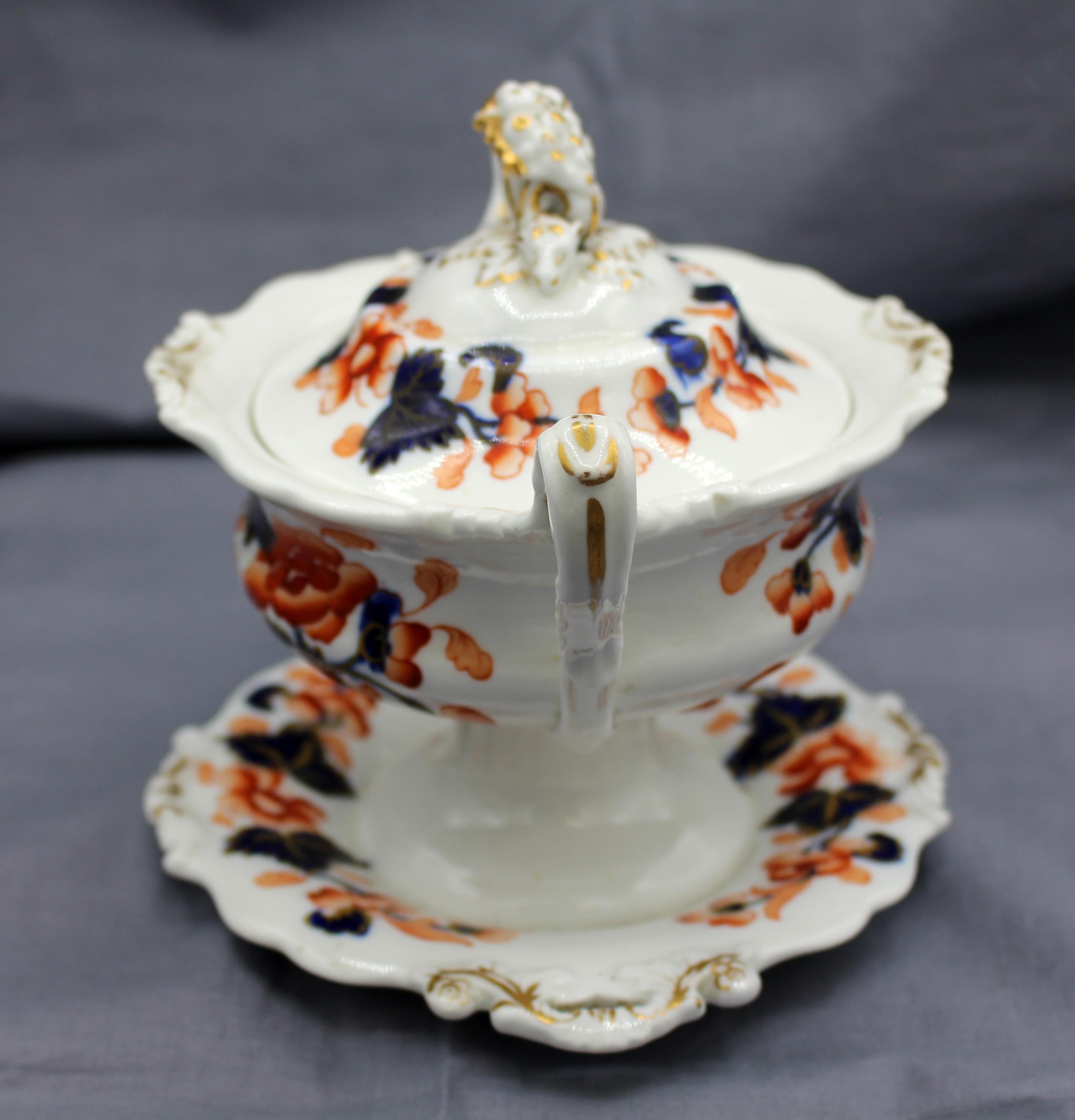 Circa 1830 English Classical period ironstone sauce tureen, integral stand & cover, Imari pattern. Finial a cornucopia with head of a fawn tip.