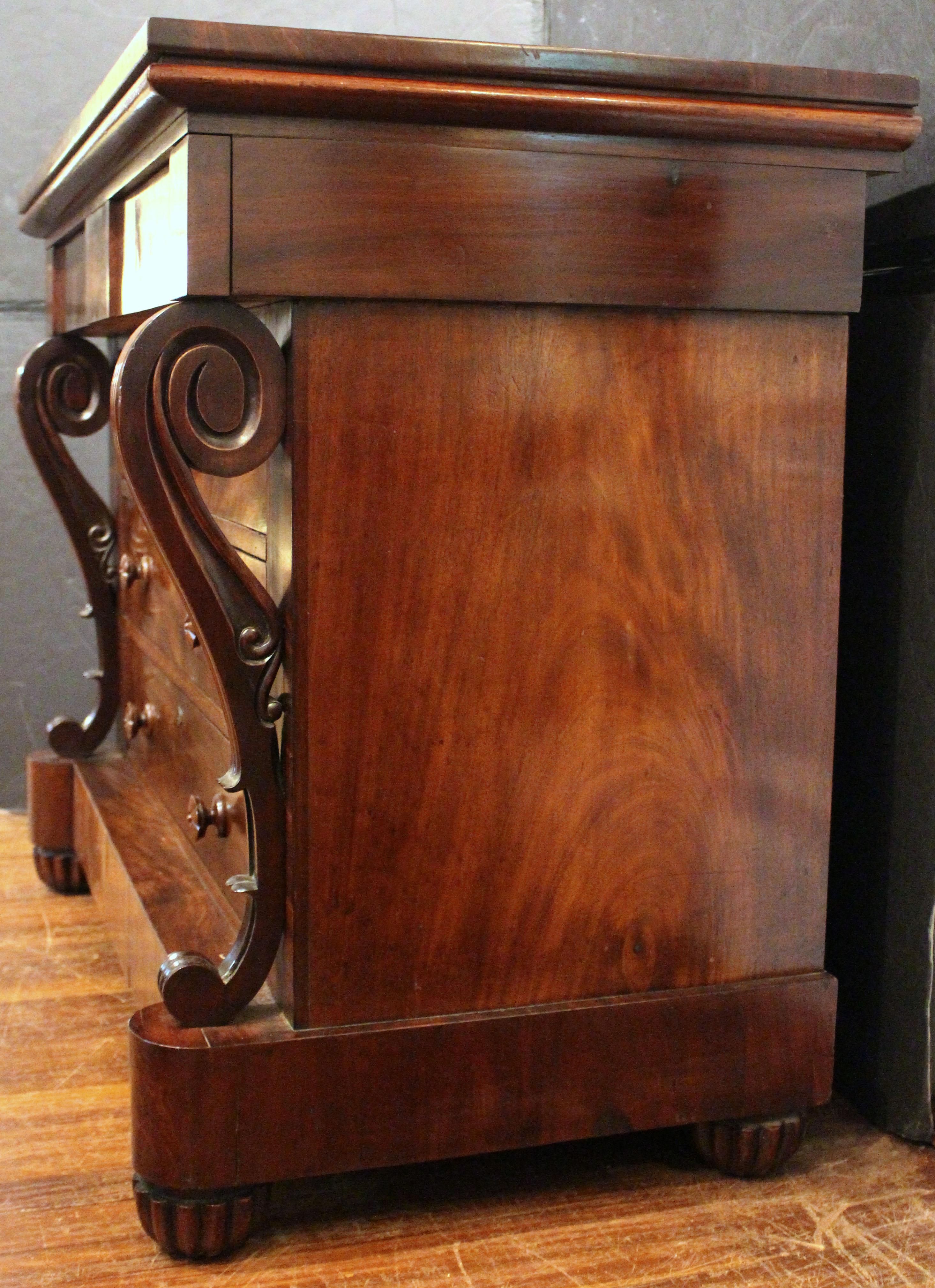 Cómoda de época William IV, inglesa, circa 1835. Forma y gusto de la cómoda francesa. Excepcionales pilastras en forma de S flanquean 3 cajones largos con tiradores de madera torneada tallada en floretes, debajo del friso con 2 cajones cortos