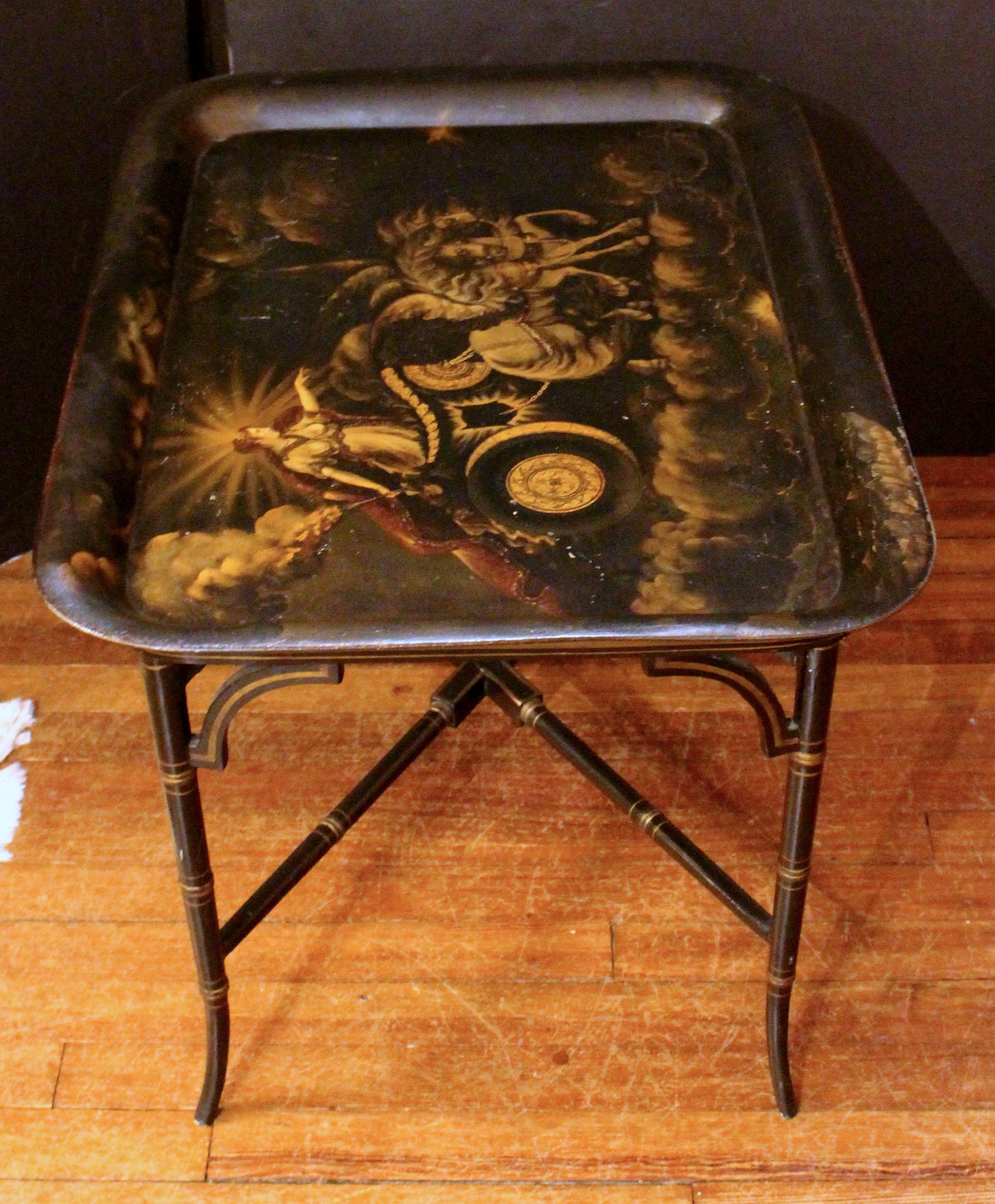 A circa 1840 well decorated tole tray now on custom coffee table height stand. The tray features the Goddess of the Dawn, Eos in Greece, Aurora in Rome, with her chariot & winged horses driving away the darkness. The wooden stand with faux bamboo