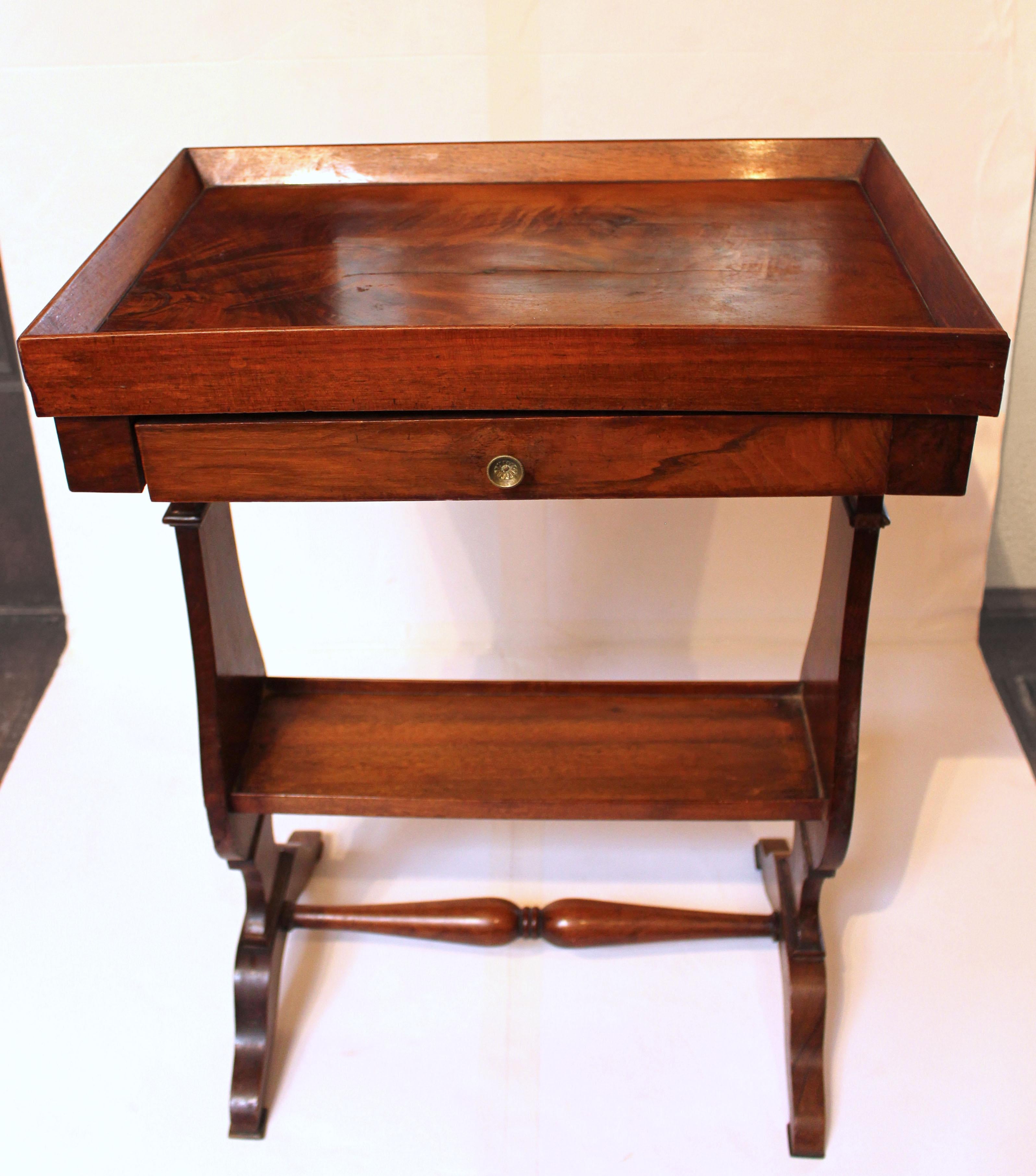 Circa 1840 Louis Philippe walnut side table, French. Gallery top over drawer with lower tier. Vasiform sides ending in shoe feet with ring carved double vasi-form turned stretcher.
19