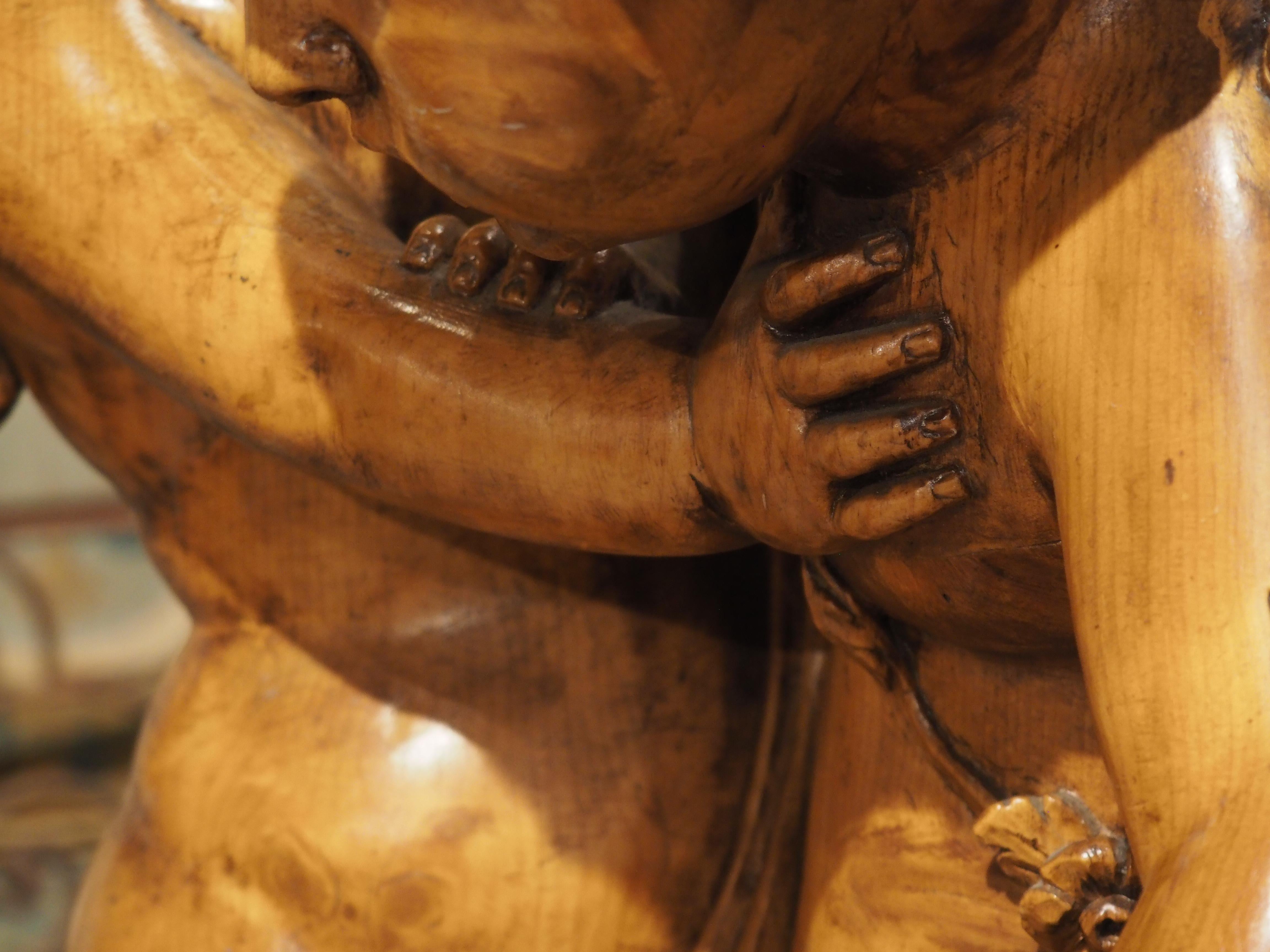 D'après la sculpture originale du CIRCA datant du XVIIIe siècle, cette sculpture française en bois, réalisée à la main vers 1850, représente les frères Eros et Anteros se disputant un cœur enflammé (symbole de la passion) sur un sol recouvert de