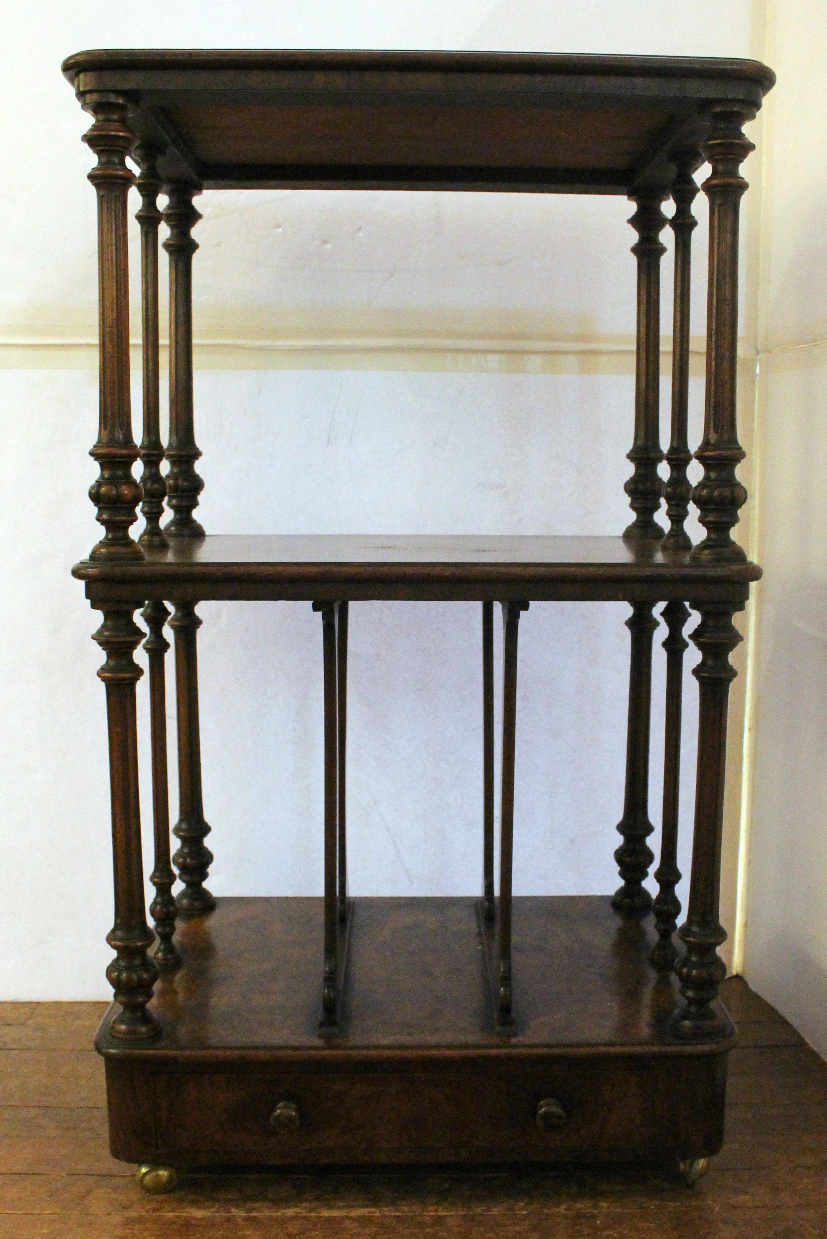 Circa 1860-80 folio or what-not stand etagere, English. For large vertical folios. Walnut & burl walnut. Turned, reeded & carved standards. Drawer in base. On casters. Once with a gallery. Provenance: Estate of Katharine Reid, former director