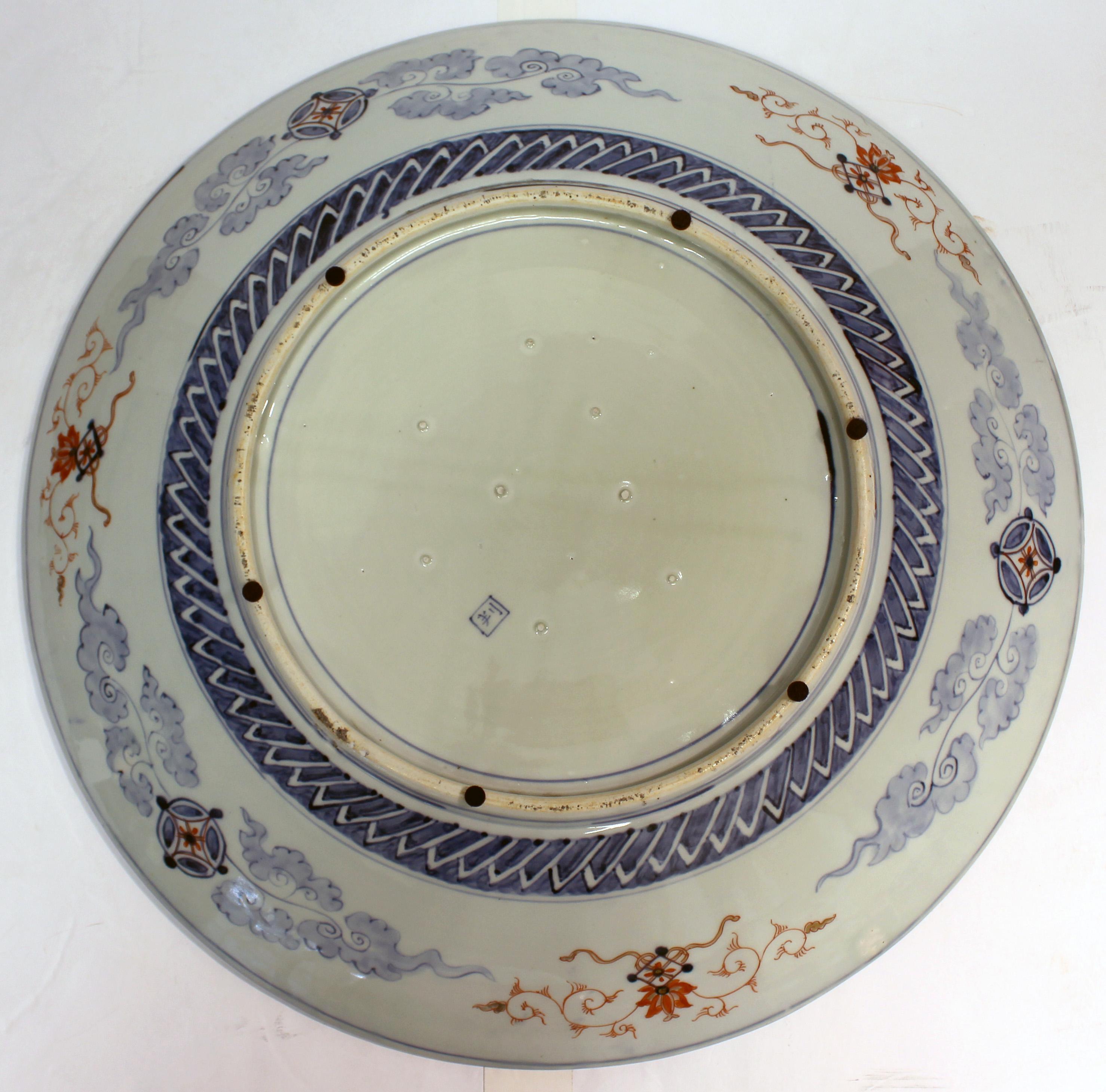 Circa 1860-80 Japanese Imari Grand Scale Charger. Meiji period. Superbly decorated with naturalistic reserves & asymmetric diapered panels; note the foo dog pair. 24.25