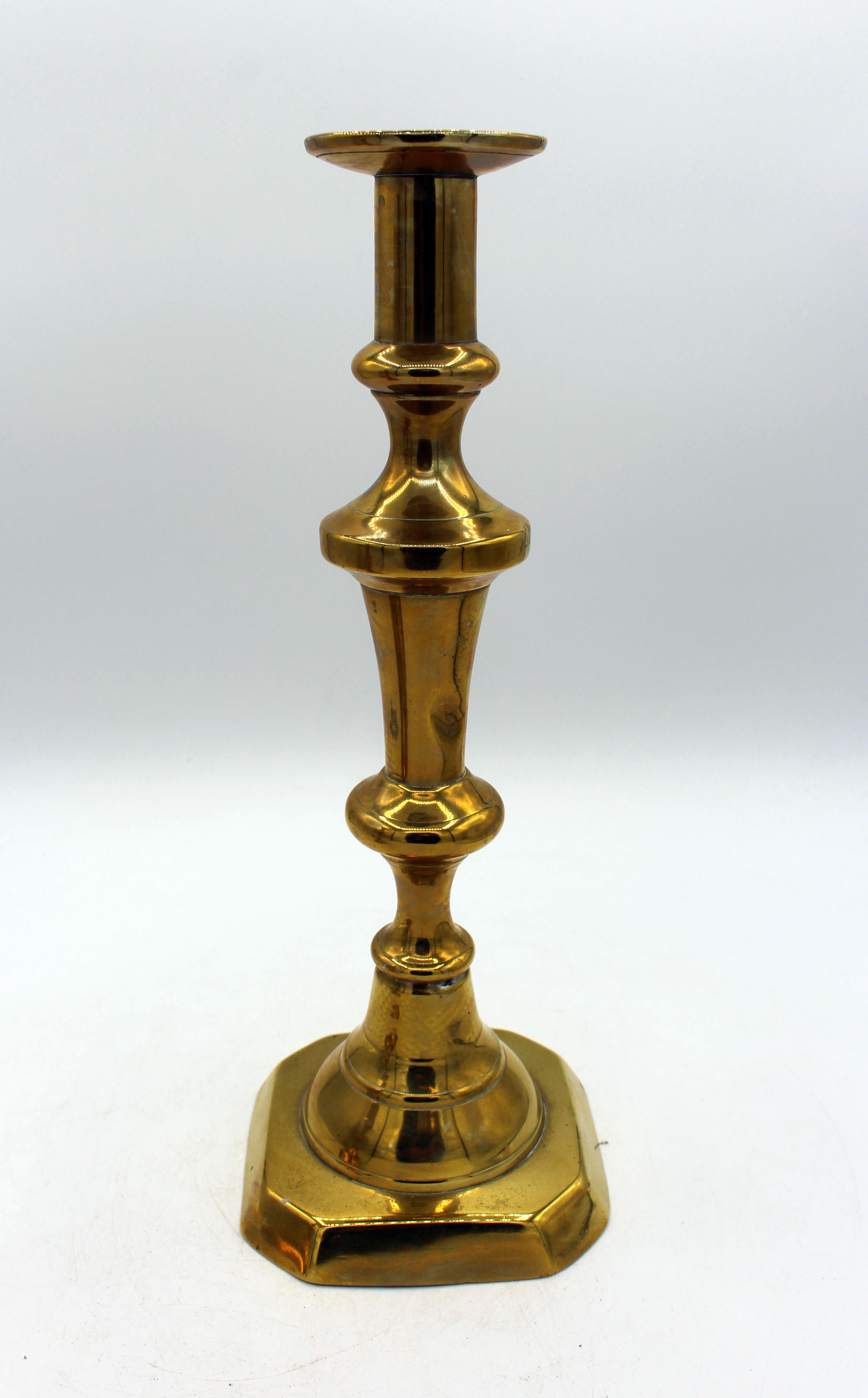 Coppia di candelieri in ottone in grande scala del 1860 circa, inglese. Basi quadrate con angoli tagliati. Ben proporzionato. Patina calda. Manca un'asta di spinta. Ammaccatura in una calotta della candela. Altezza 11 7/8