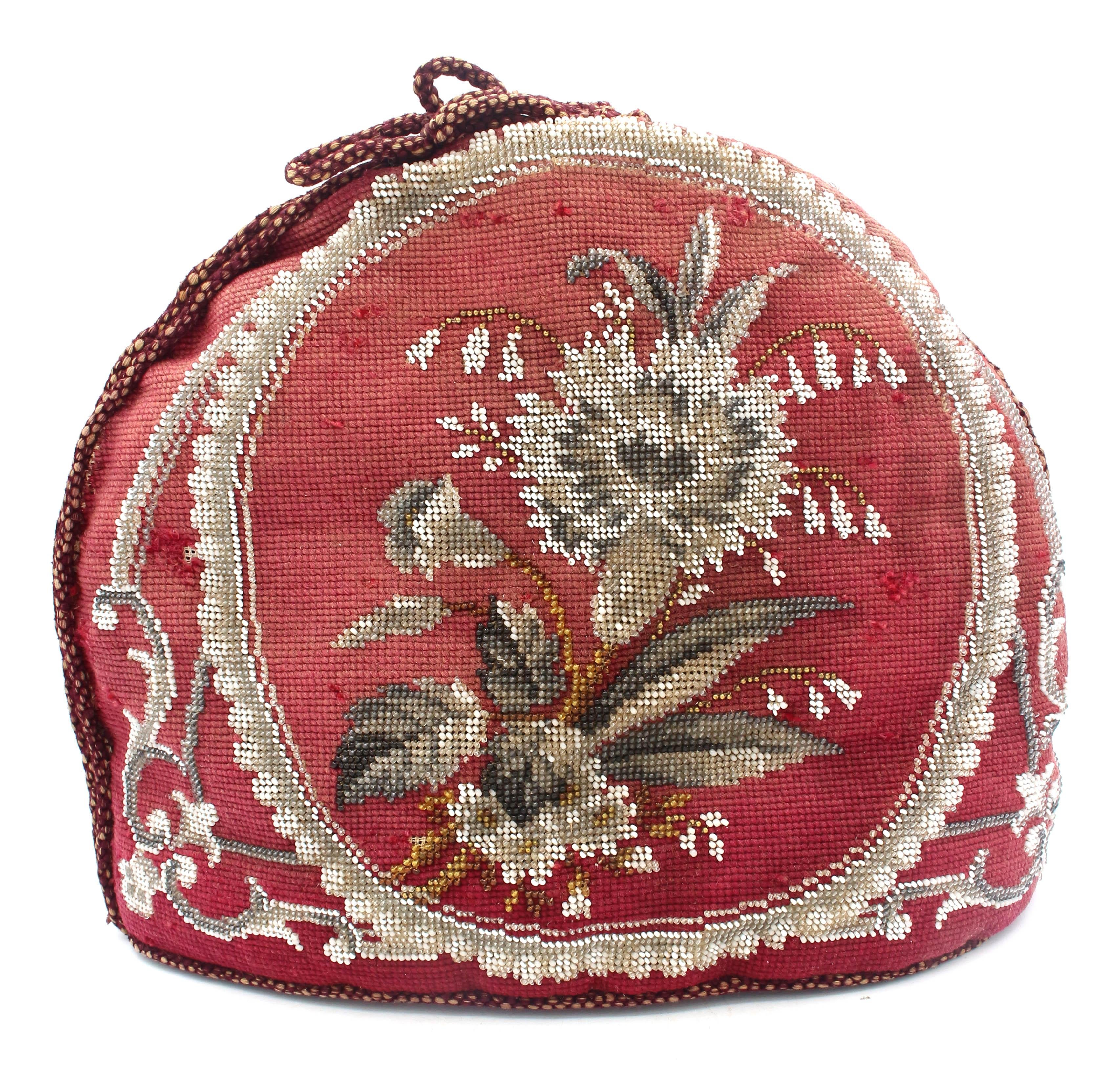 Circa 1860 English Victorian period large size tea cozy. The exterior is entirely needlepoint with each flower, leaf, stem & border of beadwork. Thousands of beads were hand woven into the facings, both opaque & translucent. The interior is burgundy