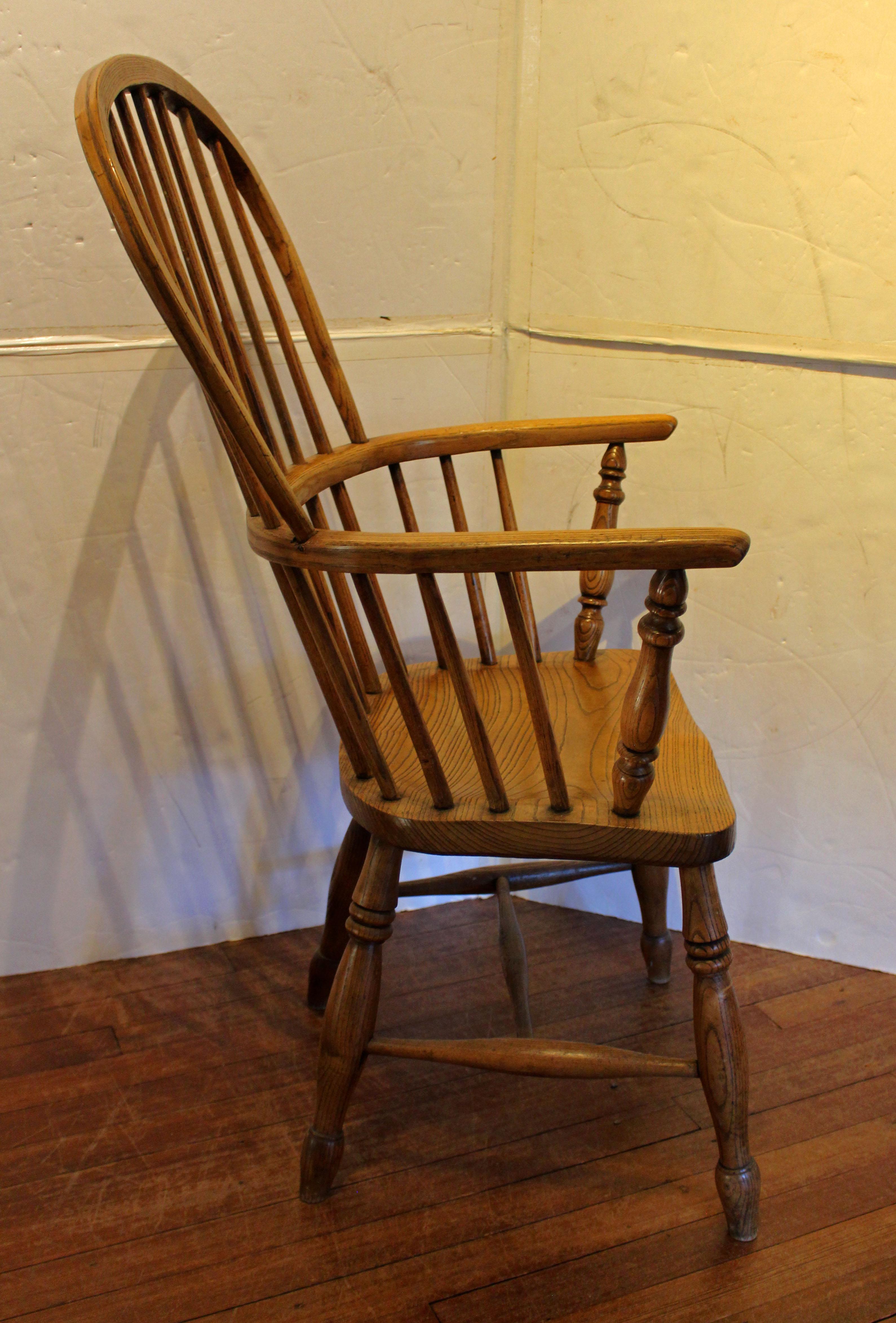 Sedia a bracci Windsor inglese del 1860 circa. Schienale a 7 fusi, braccioli e gambe tornite e sagomate, braccioli a croce torniti. Frassino con un'usura meravigliosa che esalta le venature a livello visivo e tattile. Colore sbiadito e pastoso. H.