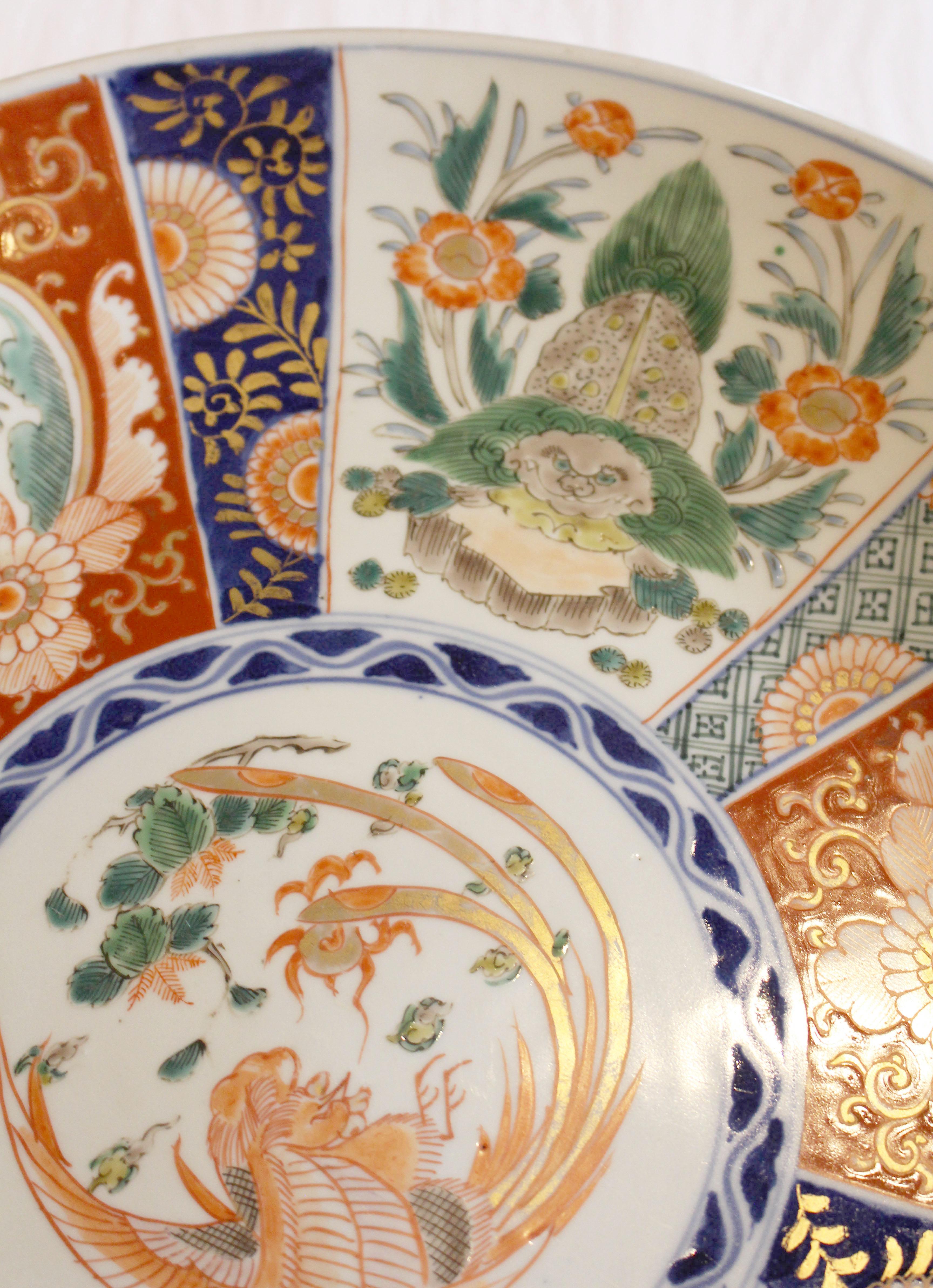 A well decorated Imari Charger. A grand phoenix central medallion surrounded by panels richly decorated with alternating burnt orange floral lozenges and foo lions in playful poses amongst floral branches. Japan, c.1860.
15 1/2