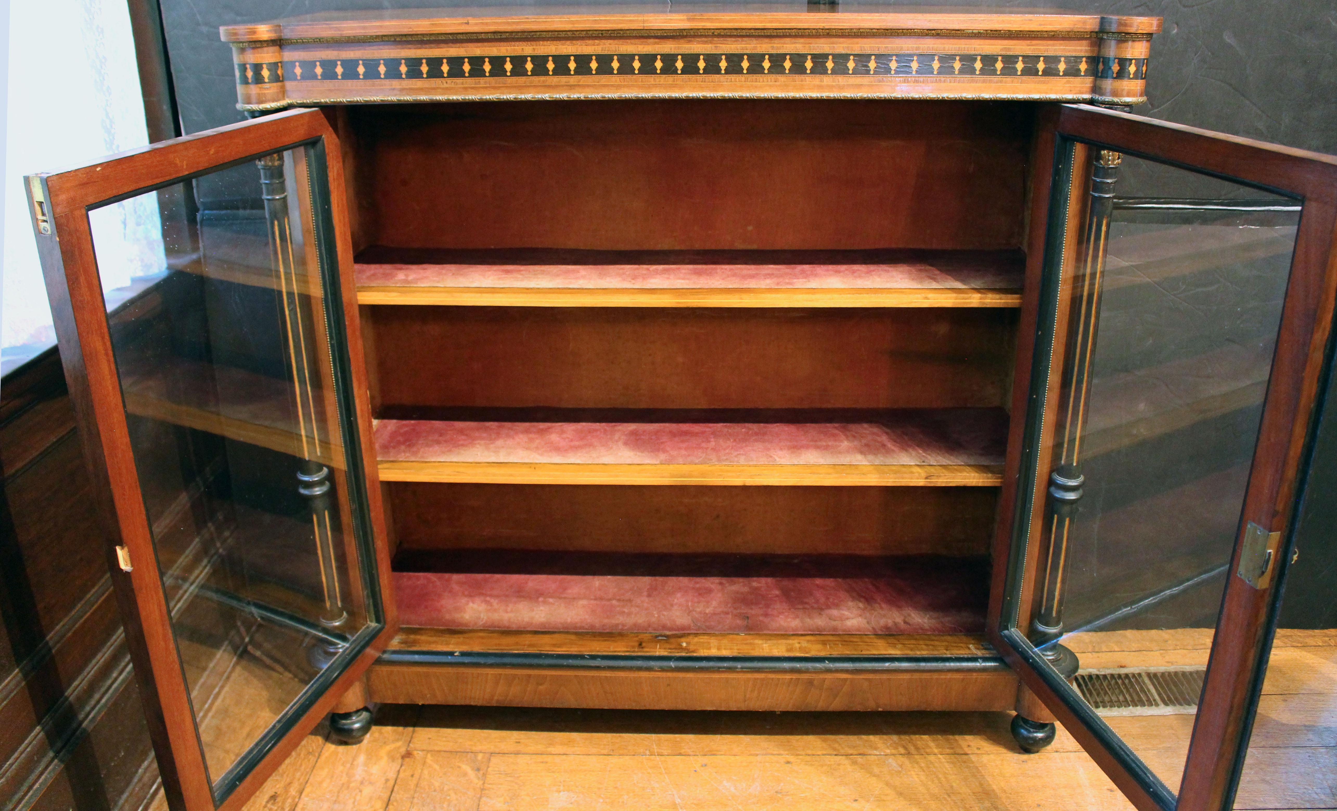 Gabinete librería Napoleón III Circa 1860, francés. Las columnas exteriores flanquean puertas de doble acristalamiento que encierran estantes forrados de terciopelo: 3 niveles para libros, accesorios, etc. Madera de nogal y ébano con numerosas