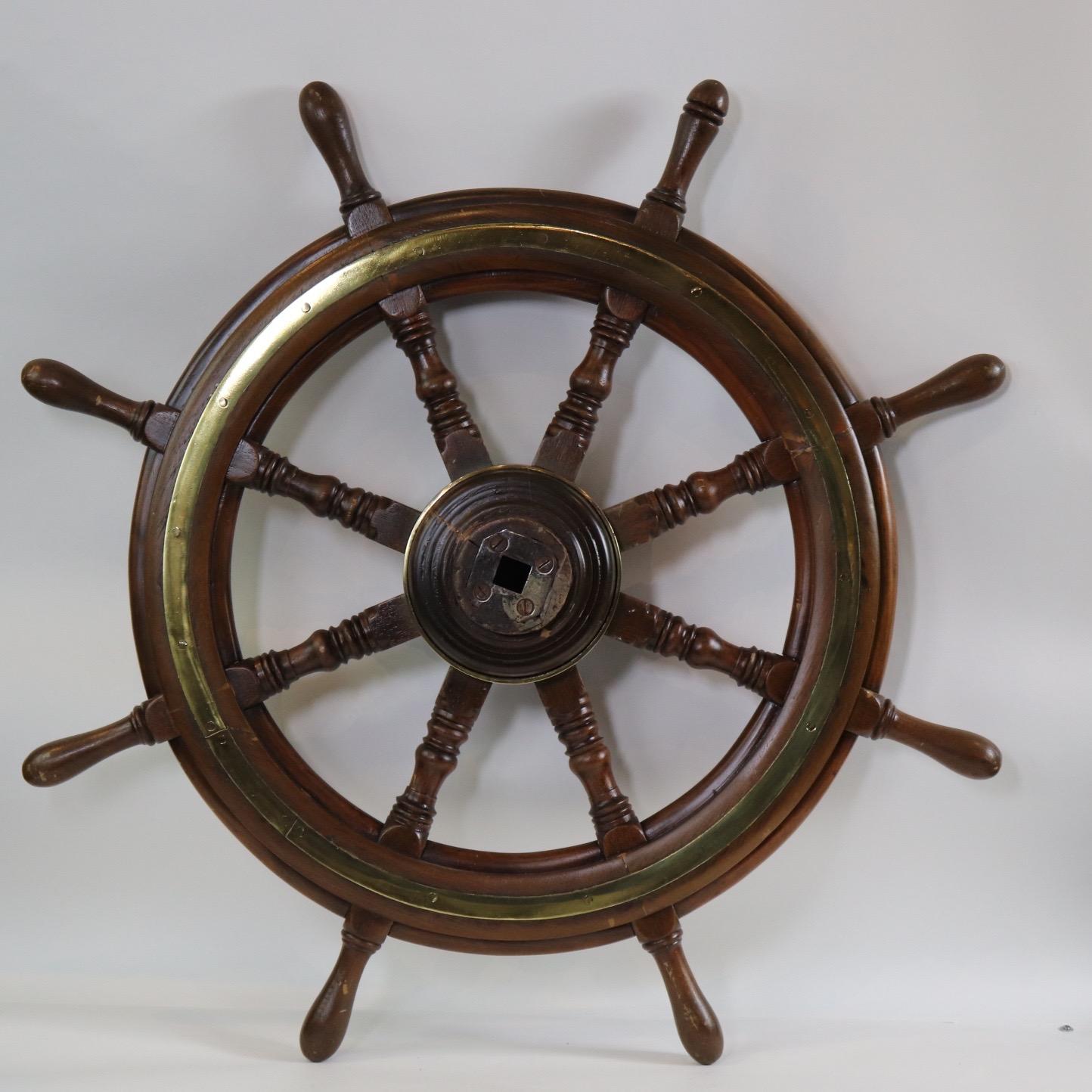Mid-19th century ships wheel with iron and wood hub, eight turned spokes, inlaid brass trim ring and brass rings around the hub. Weight is 26 pounds. X-119
