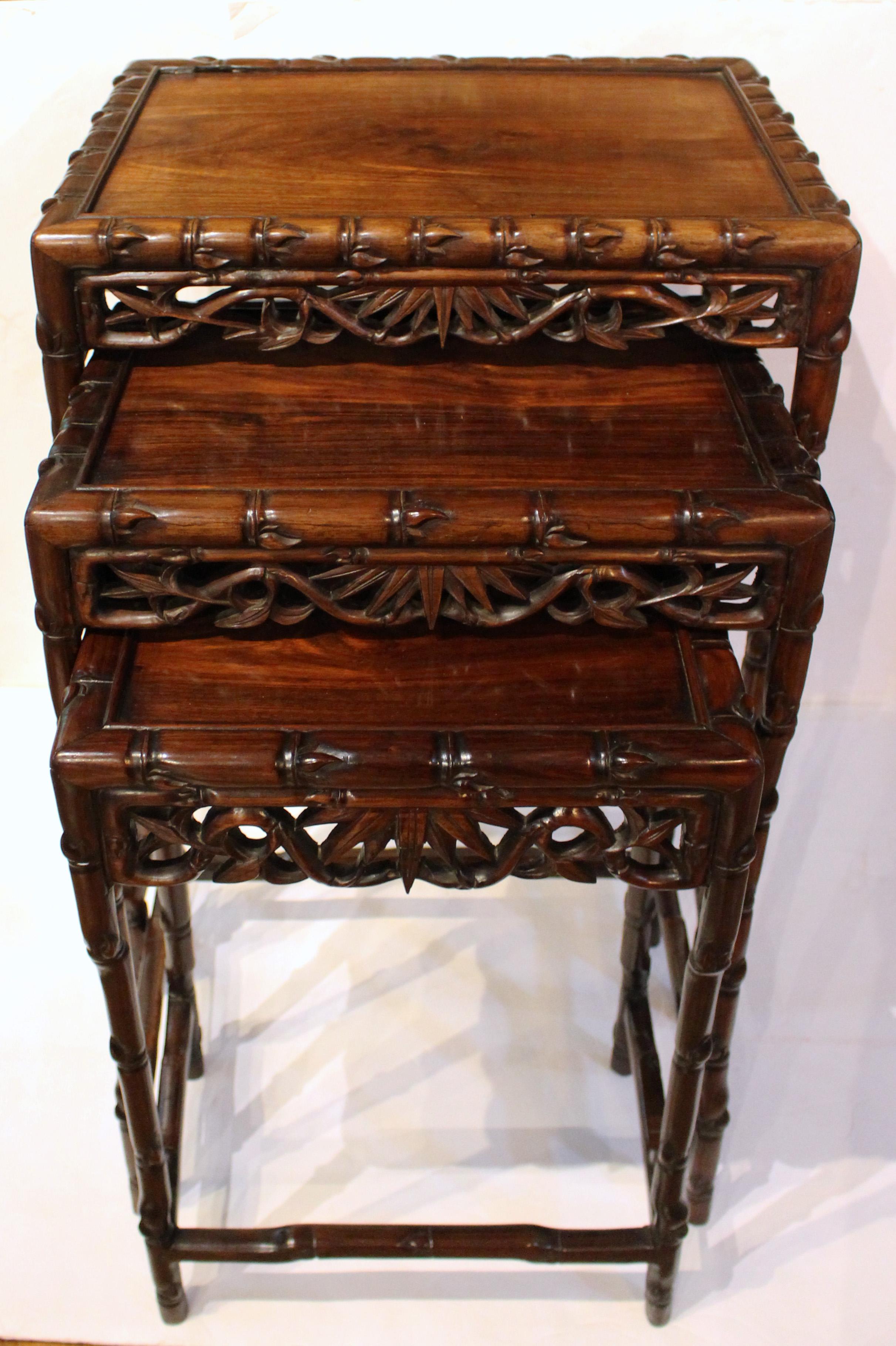 Circa 1865 set of 3 nesting tables, Chinese. Rosewood. Robust faux bamboo & bamboo leaf carvings. 3/4 stretchered. Excellent quality. Largest: 20 3/4