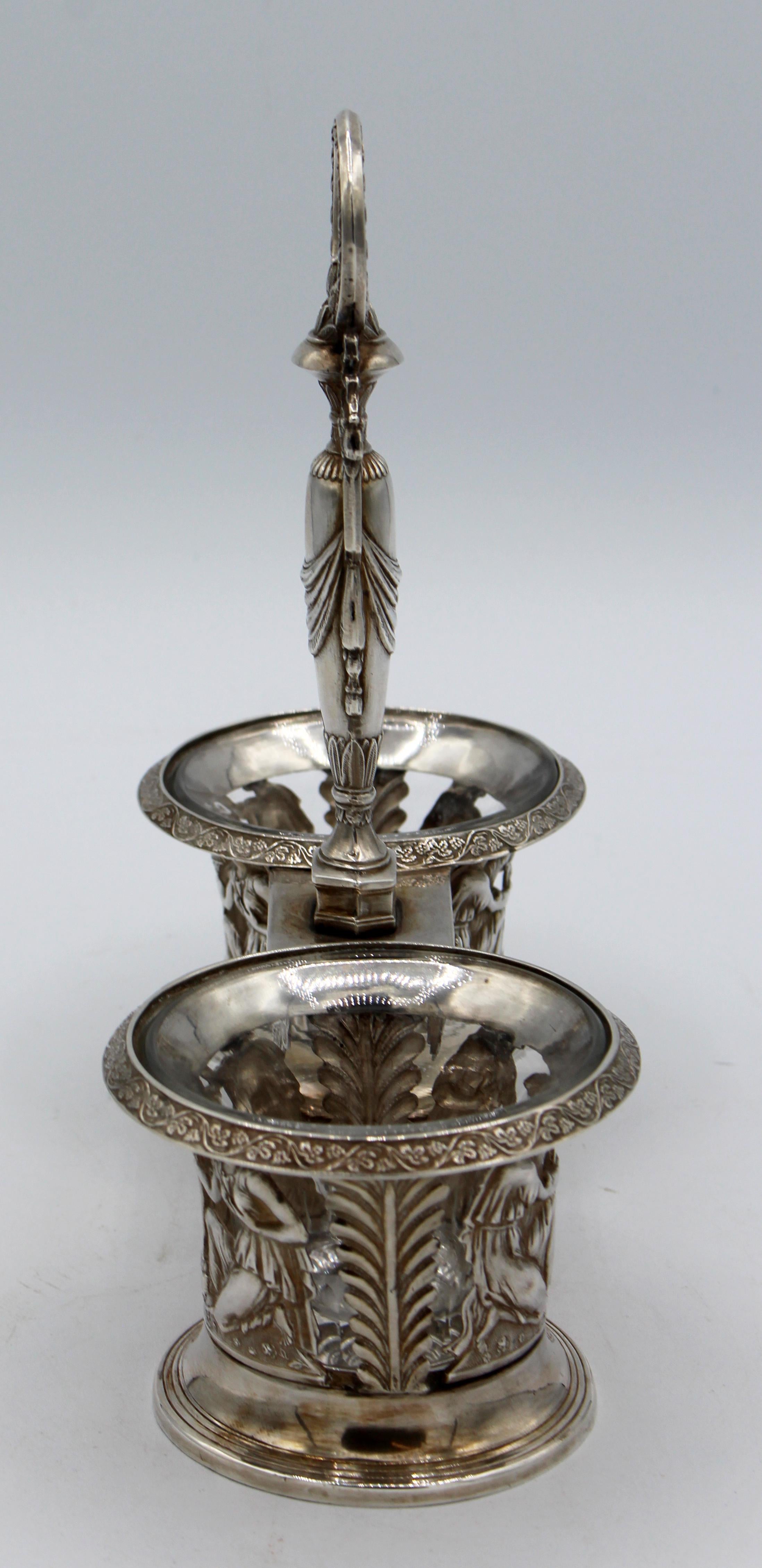 An elegant c.1870-90 neo-classical condiment set with glass inserts. Continental, 800 or higher standard silver. Zeus & Hera with eternal flame hold baskets. Ram supporters on the urn. Each part hallmarked.
Measures: 7 3/8
