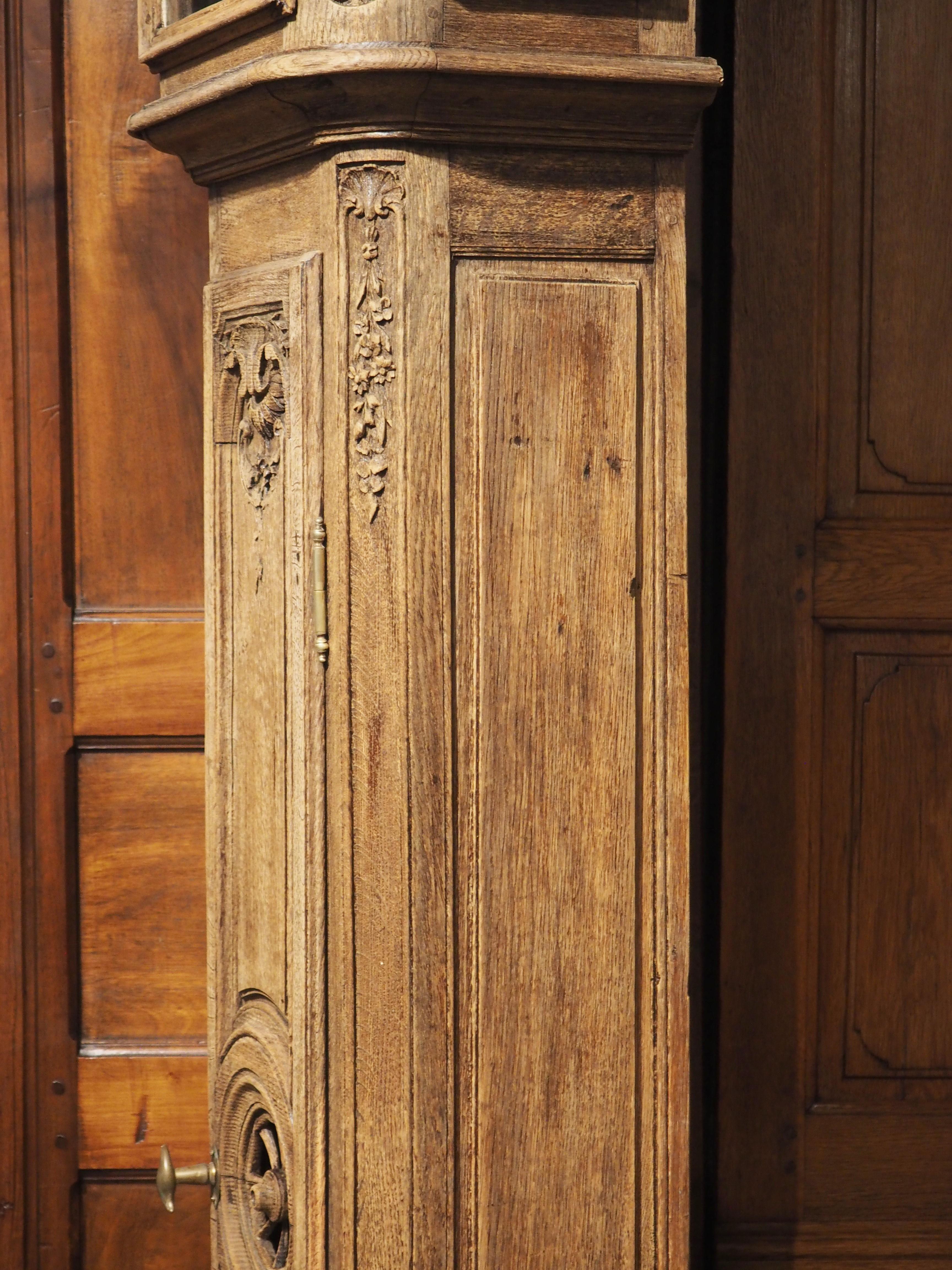 Hand-carved in Liege, Belgium circa 1870, this horloge de parquet has a commanding presence. The oak wood has been bleached, revealing great graining to the tan colored wood.

A thick base with cavetto molding on the top offers support to the