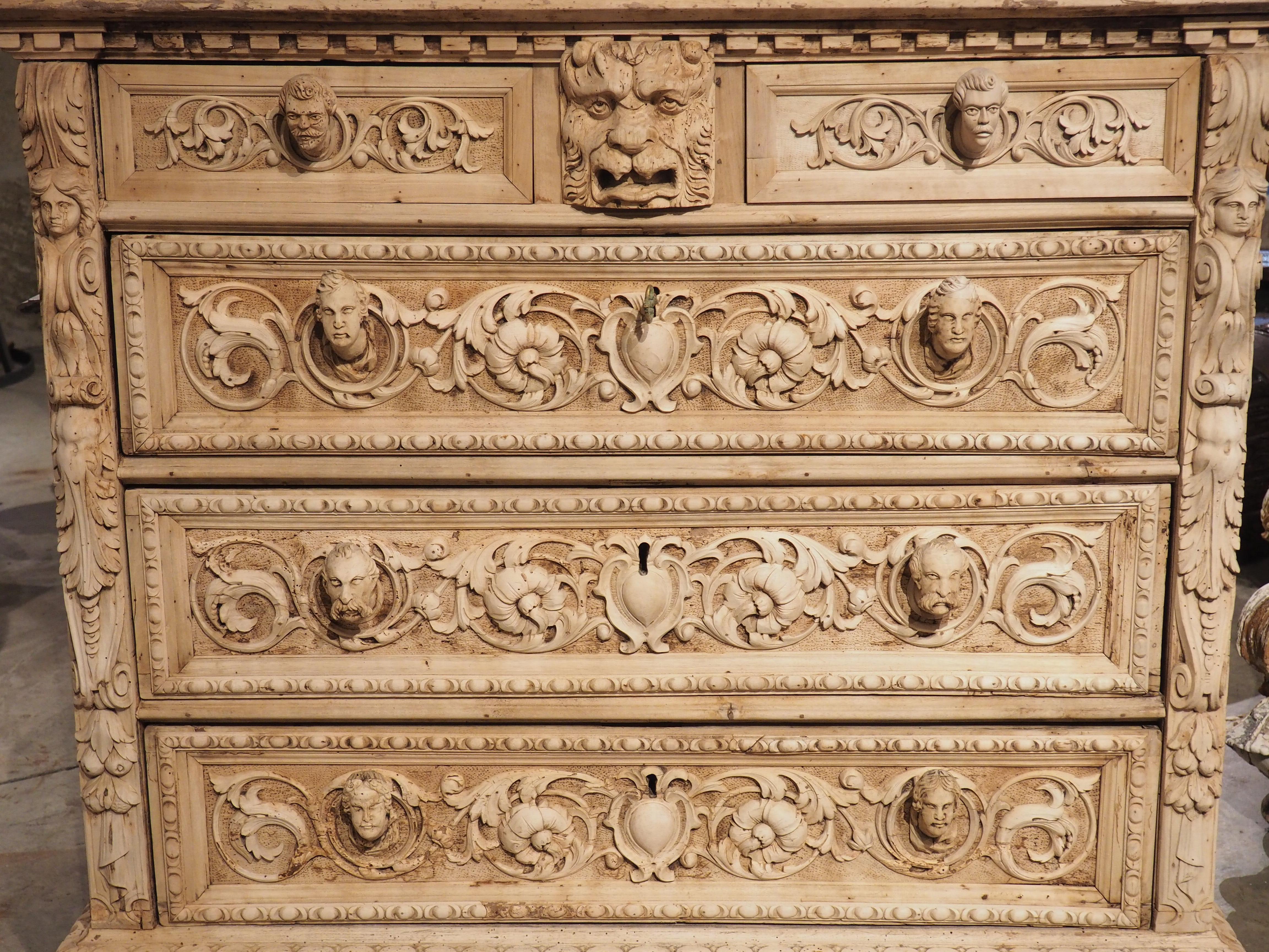 Cette majestueuse commode en noyer blanchi a été sculptée à la main par un maître italien à Florence, vers 1870. Les détails des rinceaux floraux, qui sont parsemés de mascarons en haut-relief, sont de la plus haute qualité artisanale et évoquent