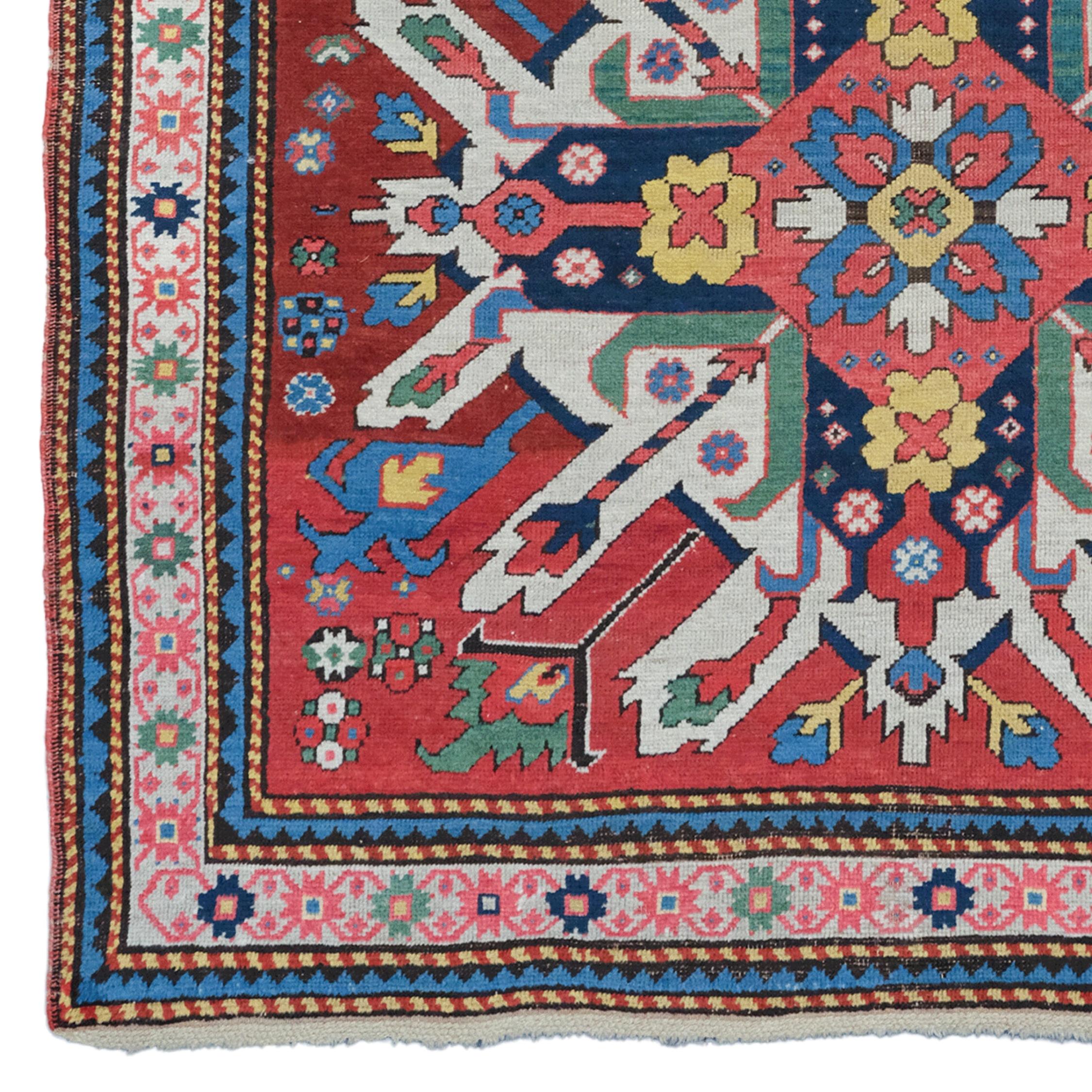 Ce tapis cosaque aigle du Caucase est un chef-d'œuvre des années 1870. Il se distingue par sa finesse d'exécution et la richesse de ses couleurs. Les motifs floraux brodés sur un fond rouge profond racontent l'histoire d'un artisanat ancien. Chaque