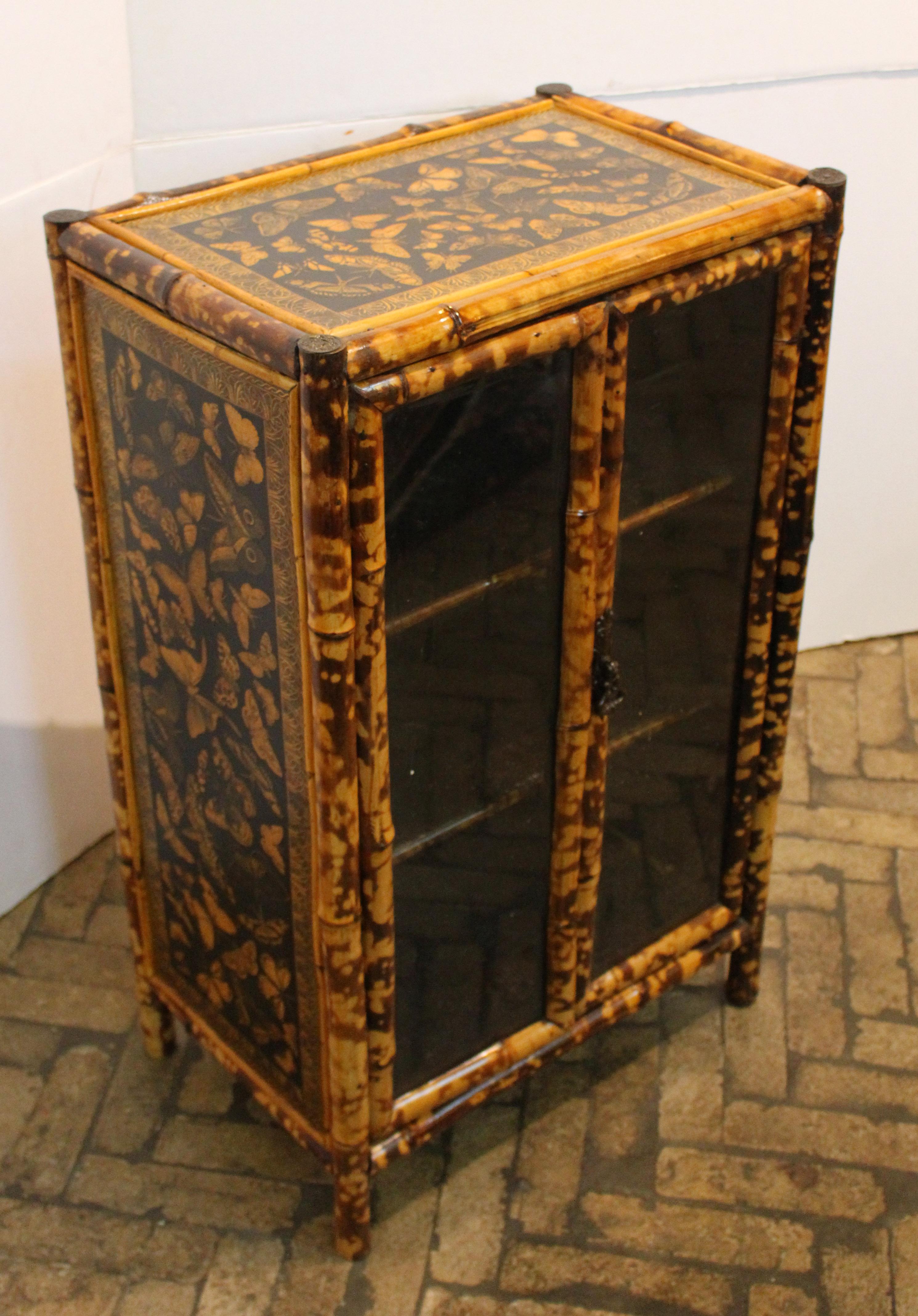 Petite double glazed door bamboo cabinet, English, c.1870. Well figured bamboo. Sweet size for many spots. Newly decoupaged with butterflies.

We are a family business that has been a major source for the selective buyer for over 90 years. We are