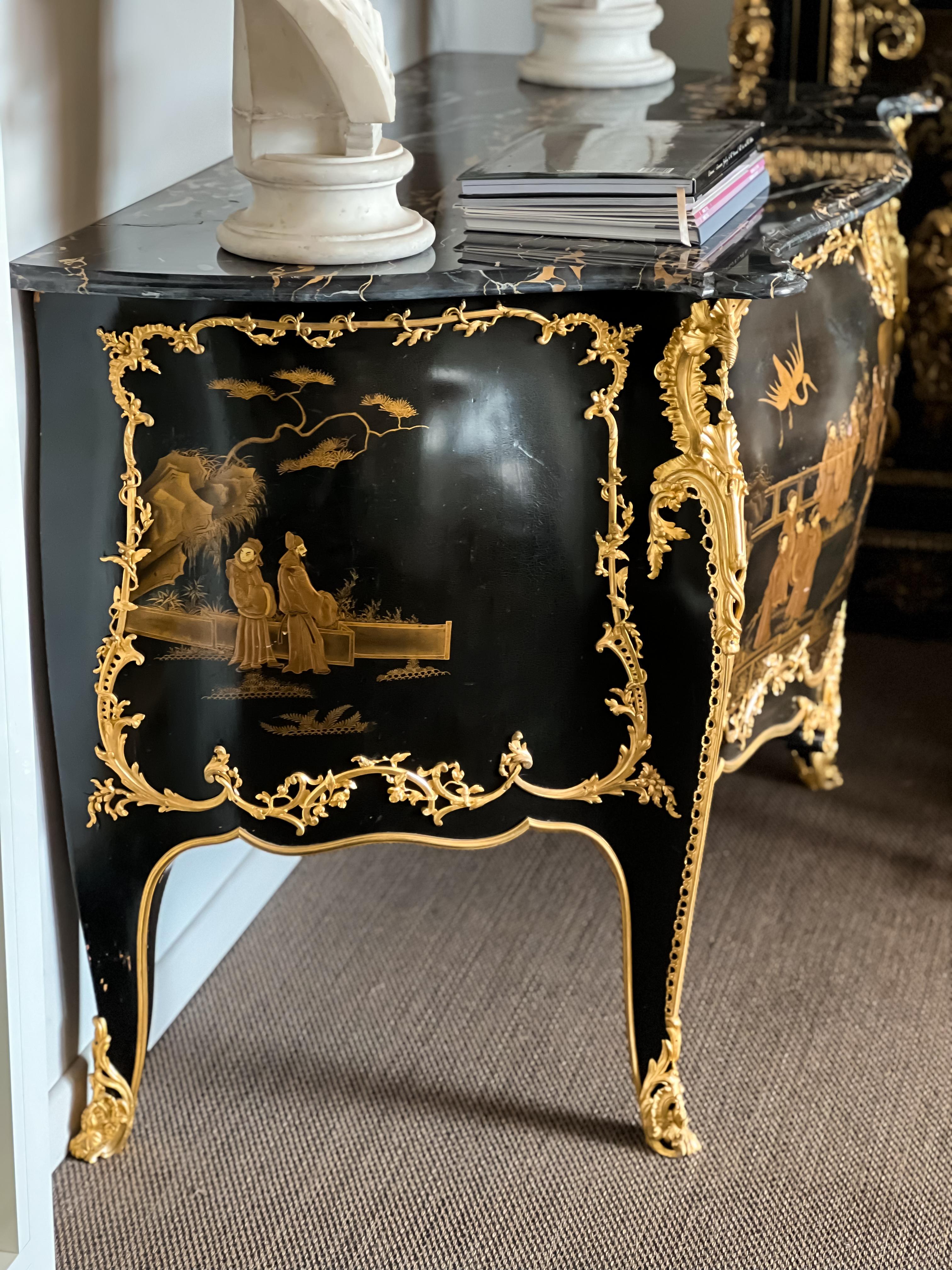 A FRENCH ORMOLU-MOUNTED GILT AND BLACK LACQUER COMMODE
BY EMMANUEL ZWIENER, PARIS, CIRCA 1880
The bombé commmode with eared black porter marble top above a central scene of chinoiserie figures in a garden, twice stamped beneath the marble top 'E.
