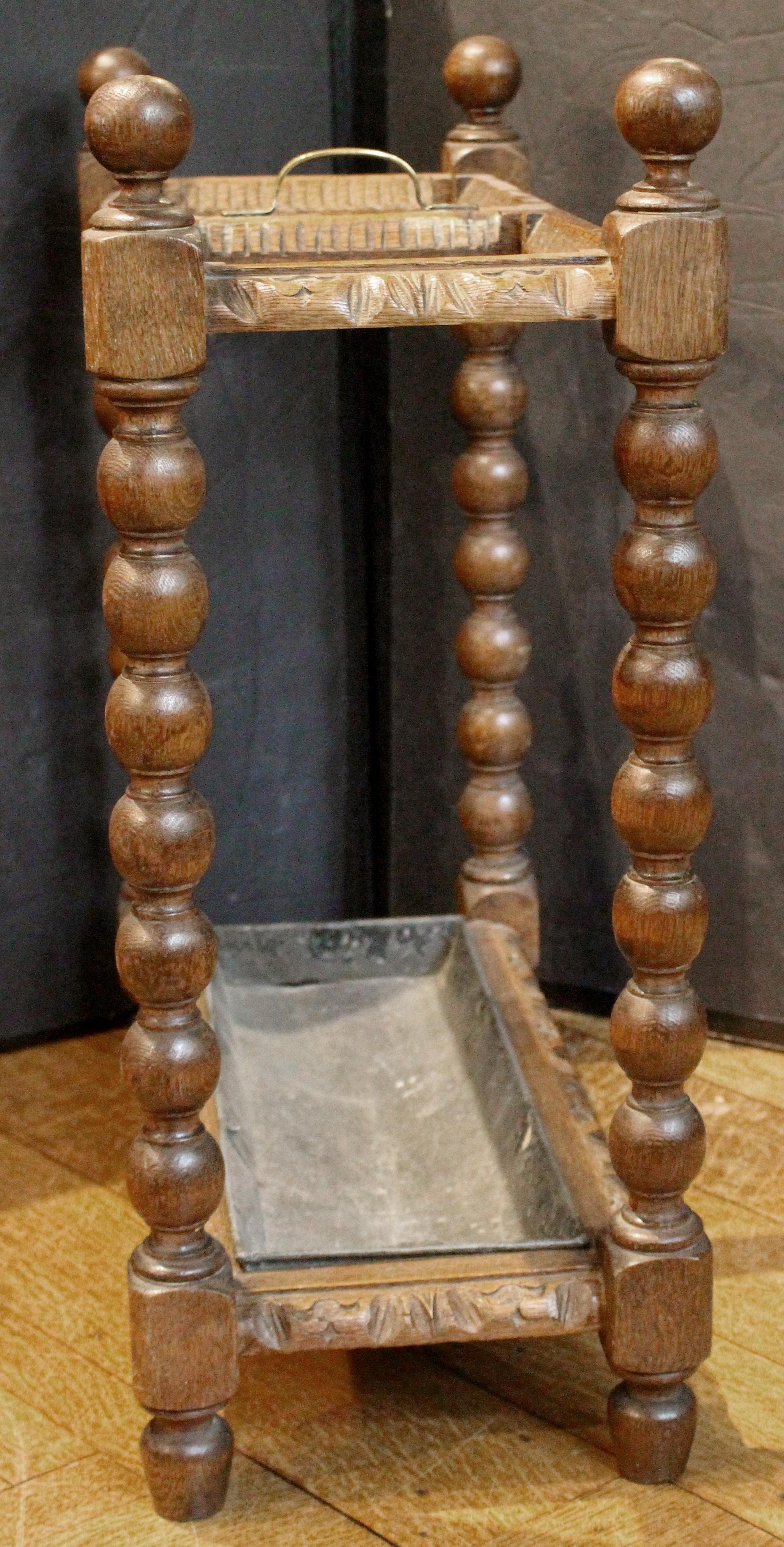 CIRCA 1880 geschnitzter Schirm- und Stockständer, englisch. Eiche mit zentralem Tragegriff aus Messing. Geklöppelte, kugelgespitzte Ständer und geschnitzte Blattstruktur. Zwei große Abschnitte. Original-Auffangschale. Riss auf einer Seite der