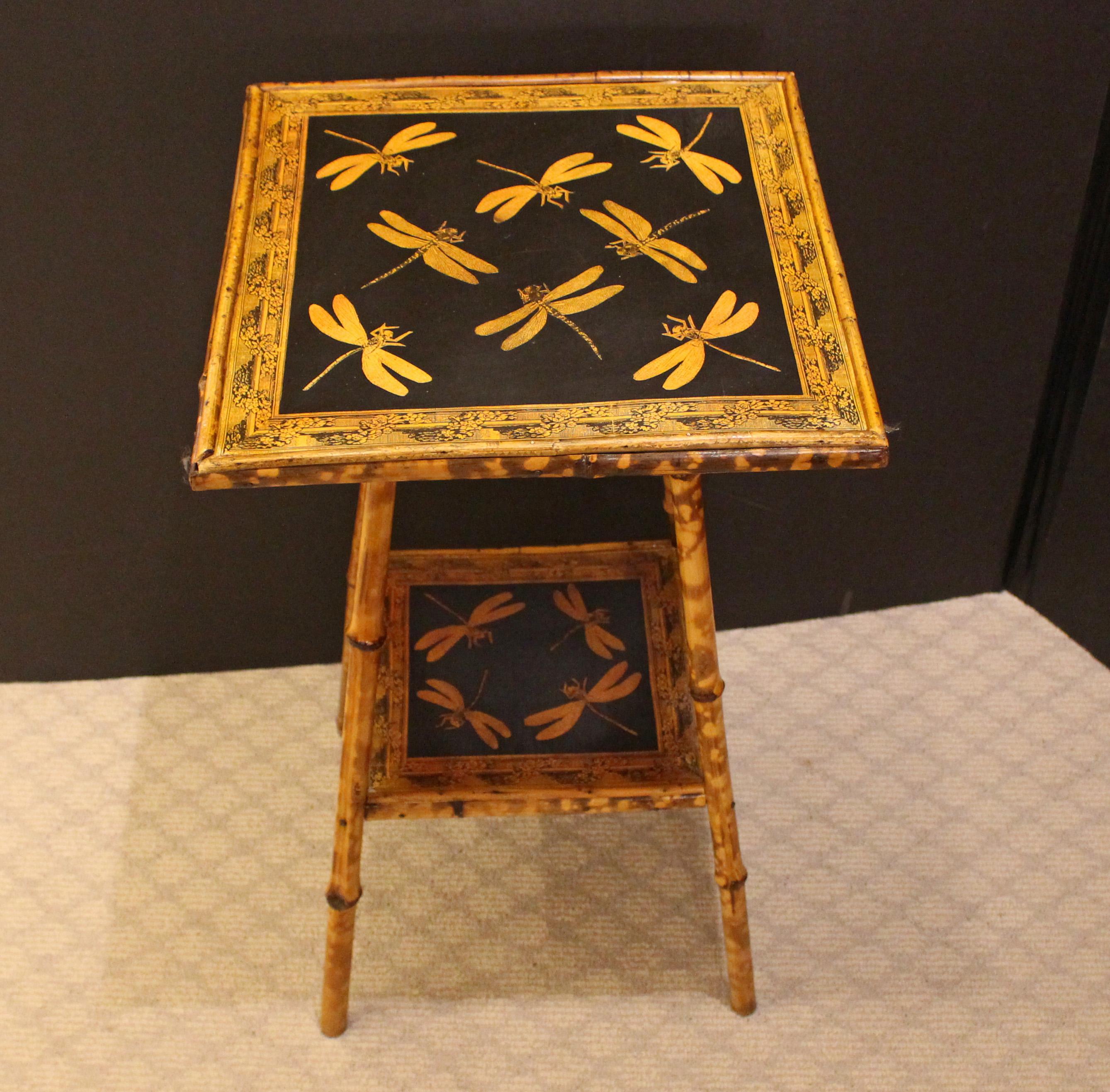 Circa 1880 English 2-tier square bamboo side table. Now decoupaged with dragonflies with floral rope motif borders. Well figured bamboo and nice stance to the straight legs. 15