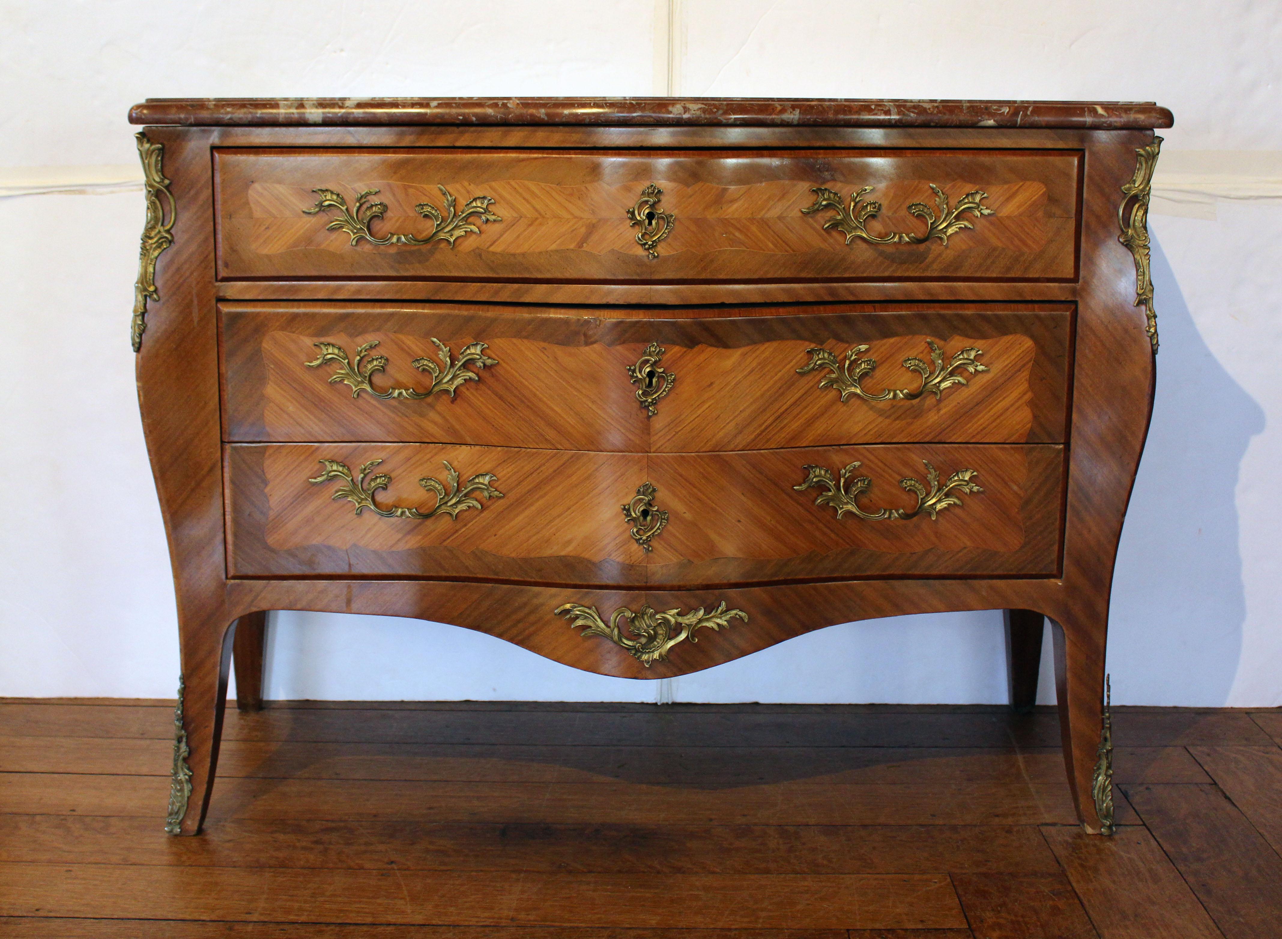 Commodo francese a 3 cassetti con piano in marmo del 1880 circa. Bellissima forma a serpentina con piano in marmo rouge de fer, in stile rococò. Impiallacciature in legno kingwood e mogano. Supporti e ferramenta in bronzo. Impiallacciature a 4