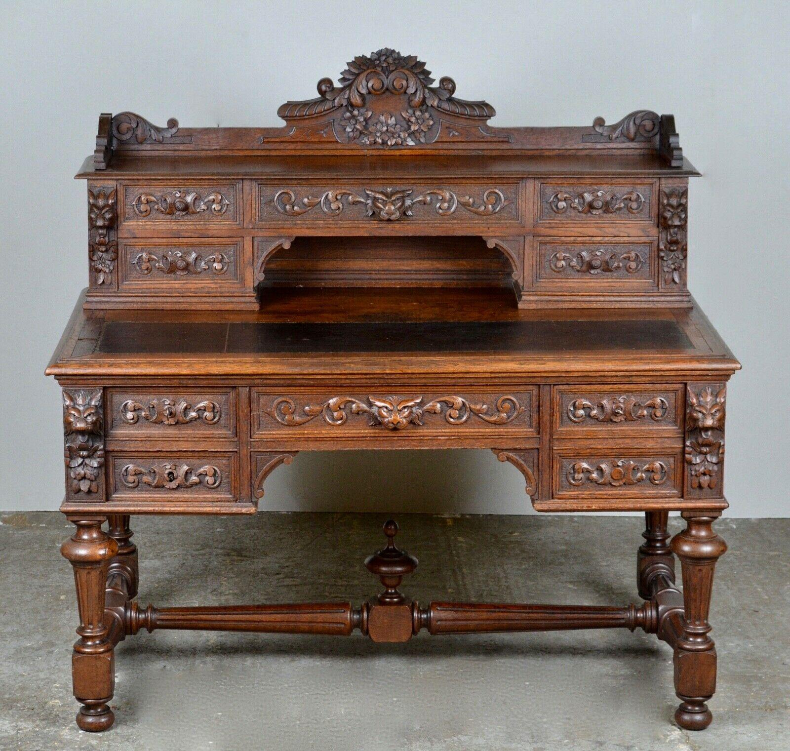 We are delighted to offer for sale this 19th century heavily carved dark oak kneehole desk. An impressive green man desk with flowers and scrolls, the superstructure having a shaped gallery back, fitted with five short drawers and an inset leather