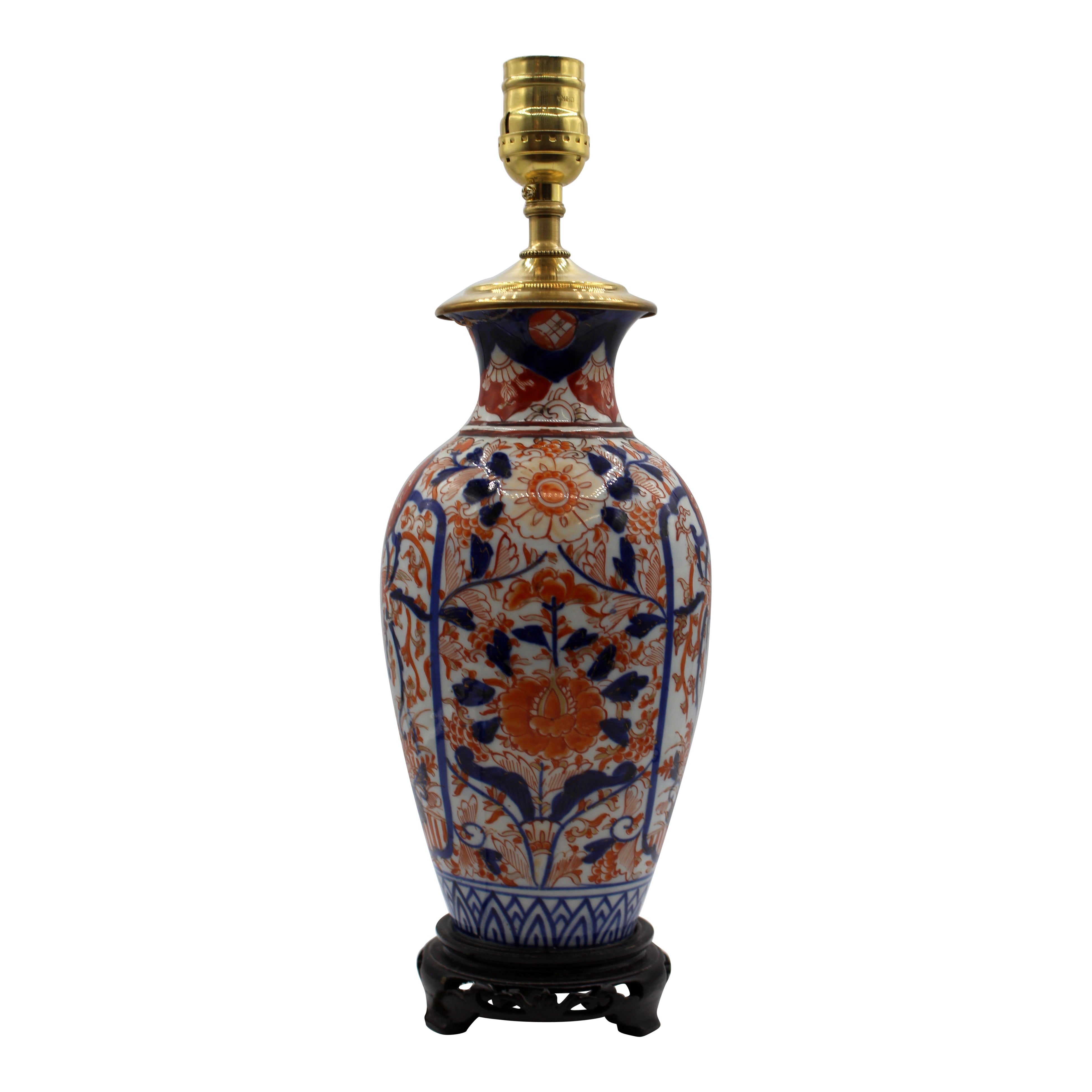 Circa 1880 Japanese Imari vase now as a table lamp. Decorated with opposing reserves featuring a foo dog medallion over a phoenix with foliage & sides with extensive floral & foliage decoration. Carved wood base. Restoration to the underside of the