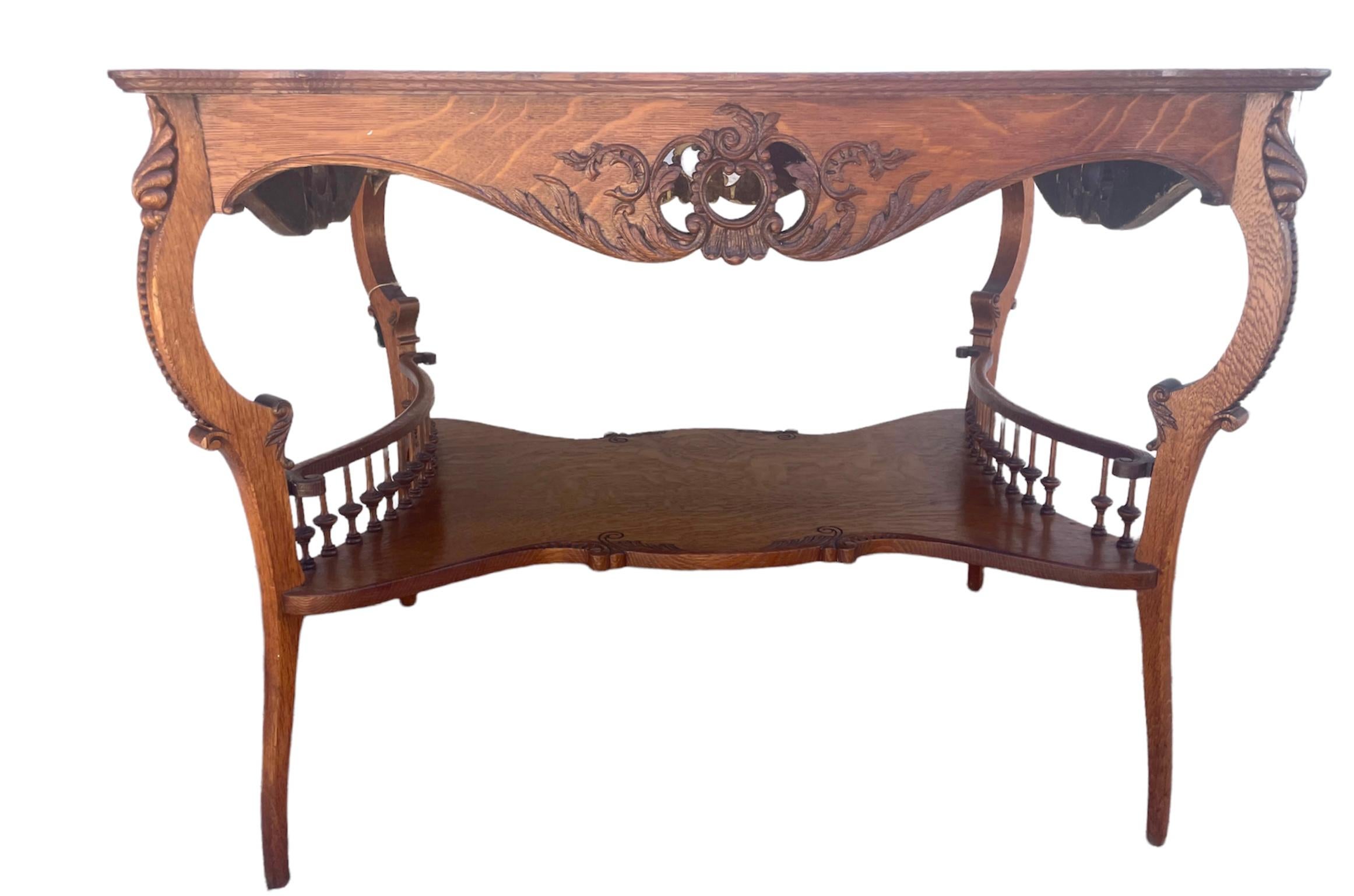 What a beauty- this antique palour lamp table is tiger oak and is so eye catching and the carved design is spectacular and all in fantastic shape- only 1 spindle is missing. A natural split runs down the middle but not loose, structurally sound,