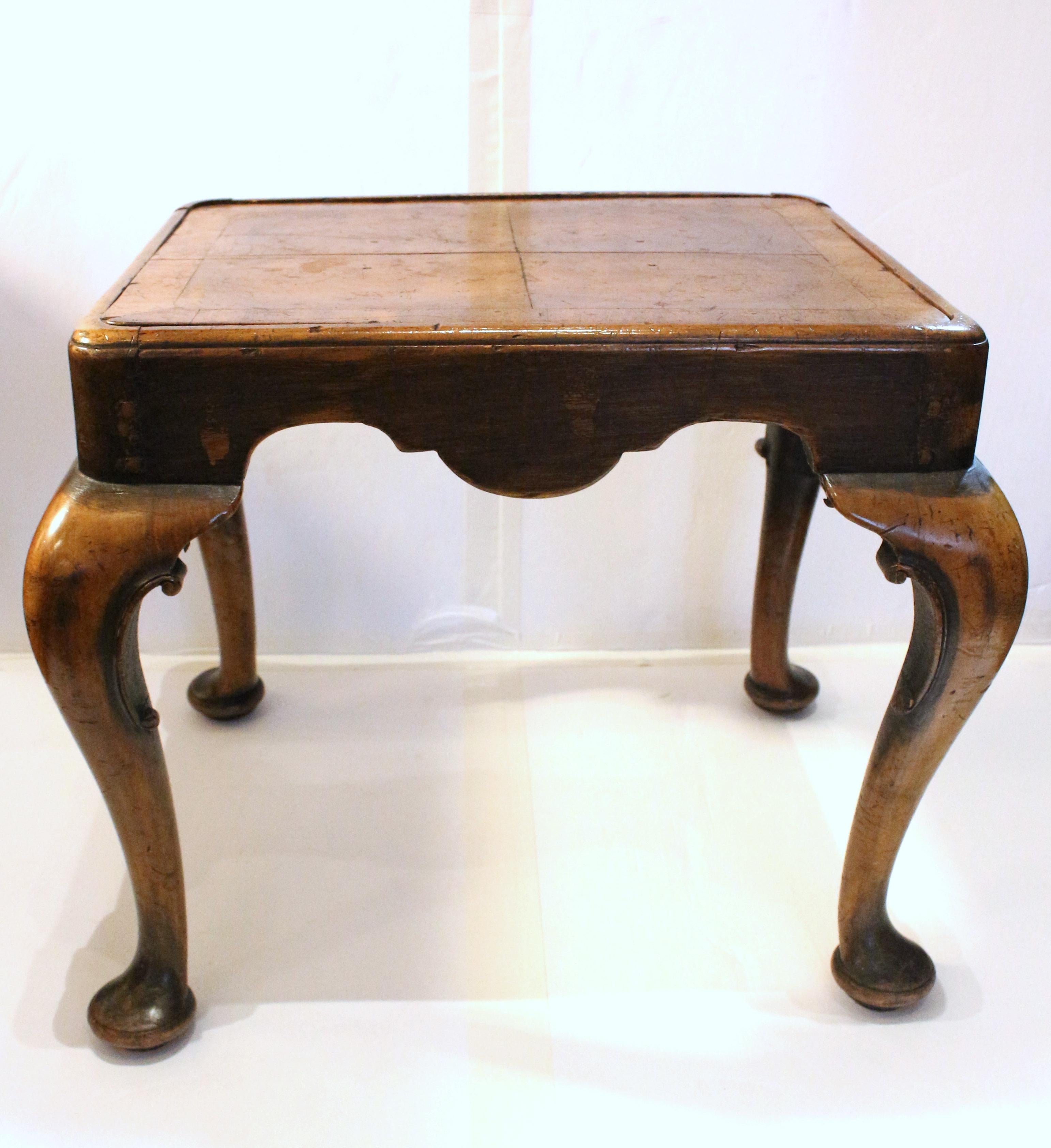 Circa 1880 Queen Anne style footstool or small bench, English. Walnut. Very well executed cabriole legs with c-scroll moldings & pad feet. Inset, removable walnut seat with loose needlework cushion. Could be used as a table given the beautiful