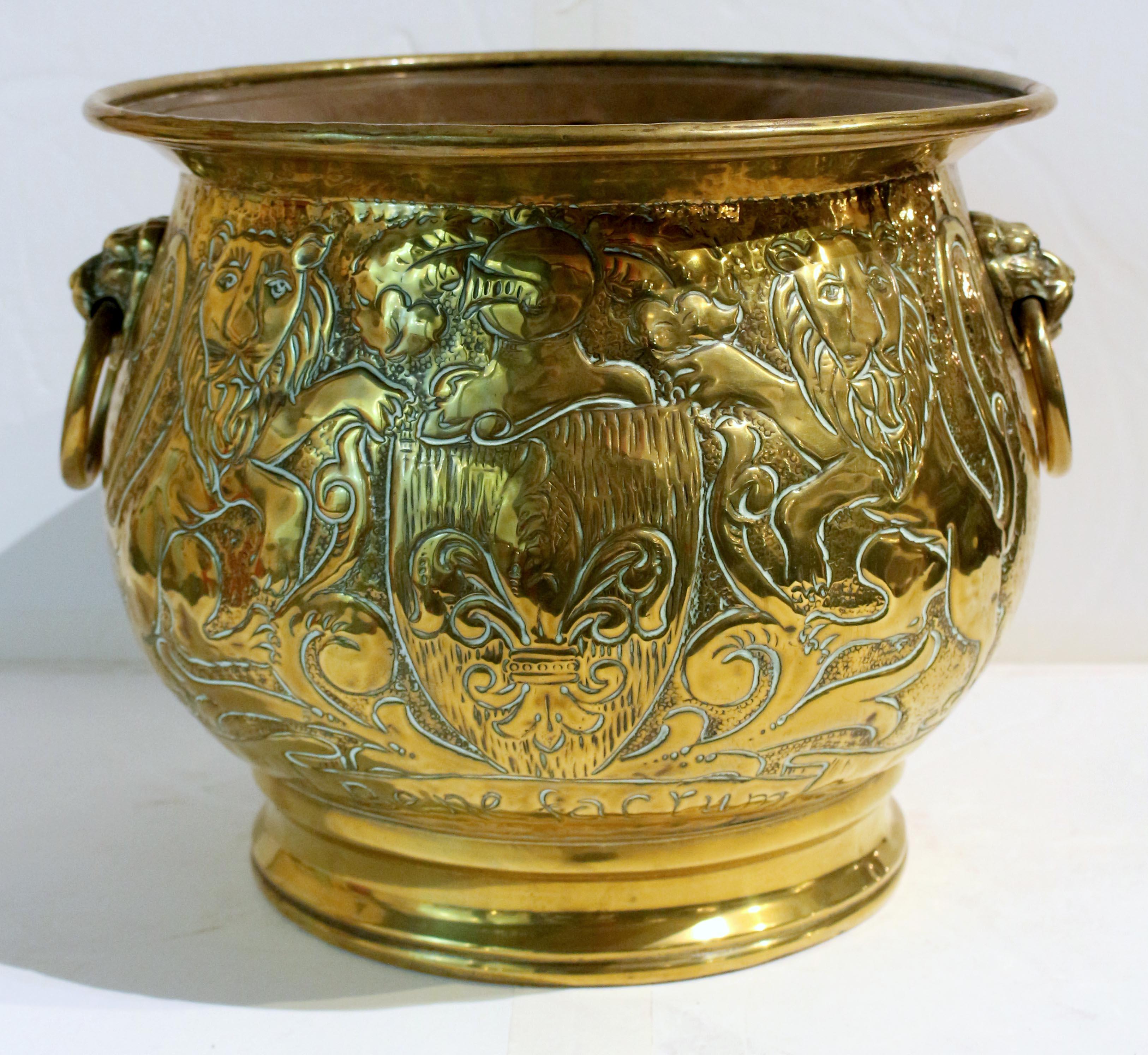 Circa 1880 round brass handled jardiniere, English. Very well decorated with rampant lions flanking a crest with knight's helmet surmounting a shield with fleur de lys with 